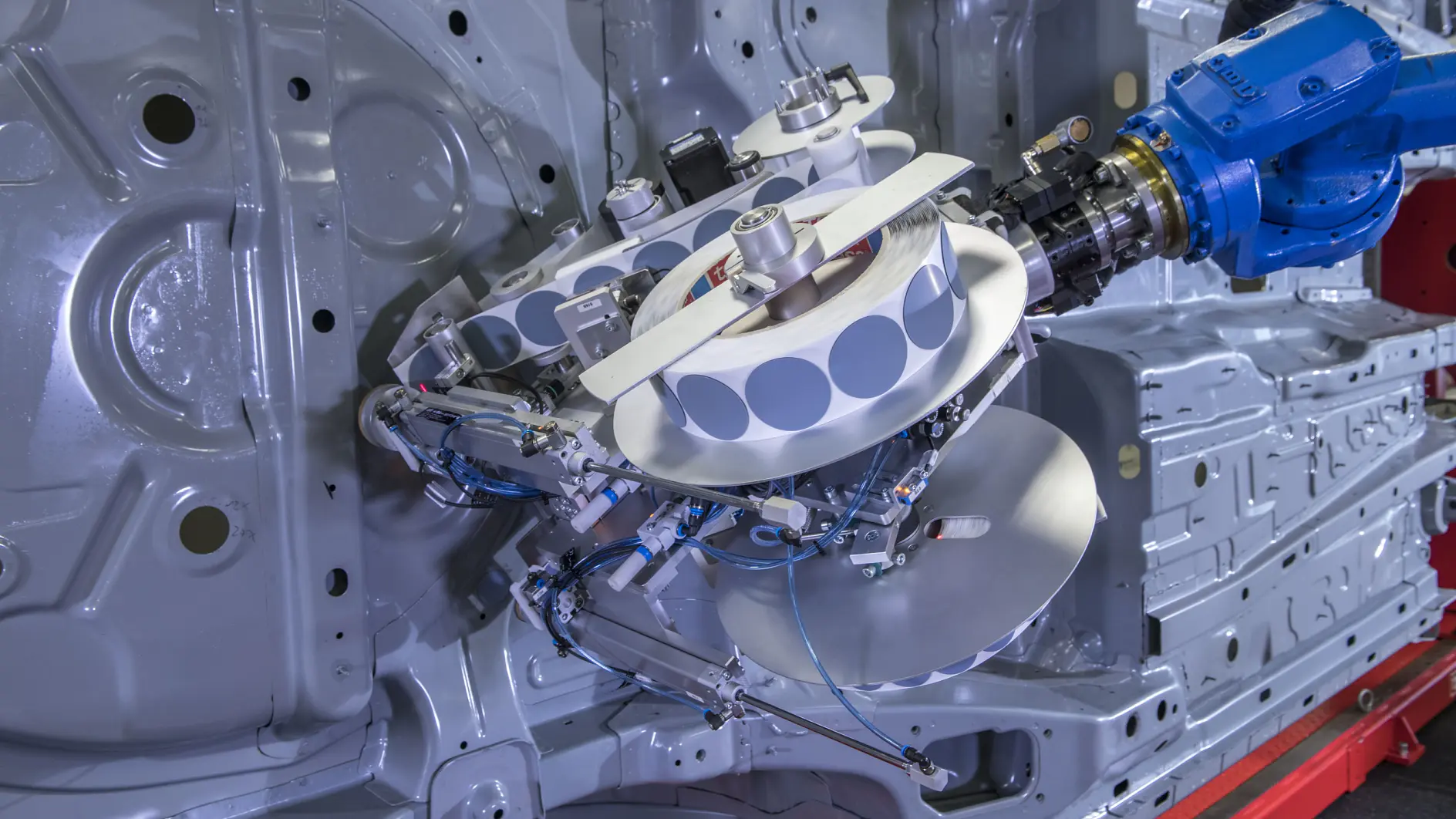 Las almohadillas adhesivas de tesa se colocan de forma rápida y fiable mediante un robot. Antes de esta innovación, el tapado de agujeros era un proceso agotador y que requería mucho tiempo, que tenía que hacerse a mano. (© tesa SE)