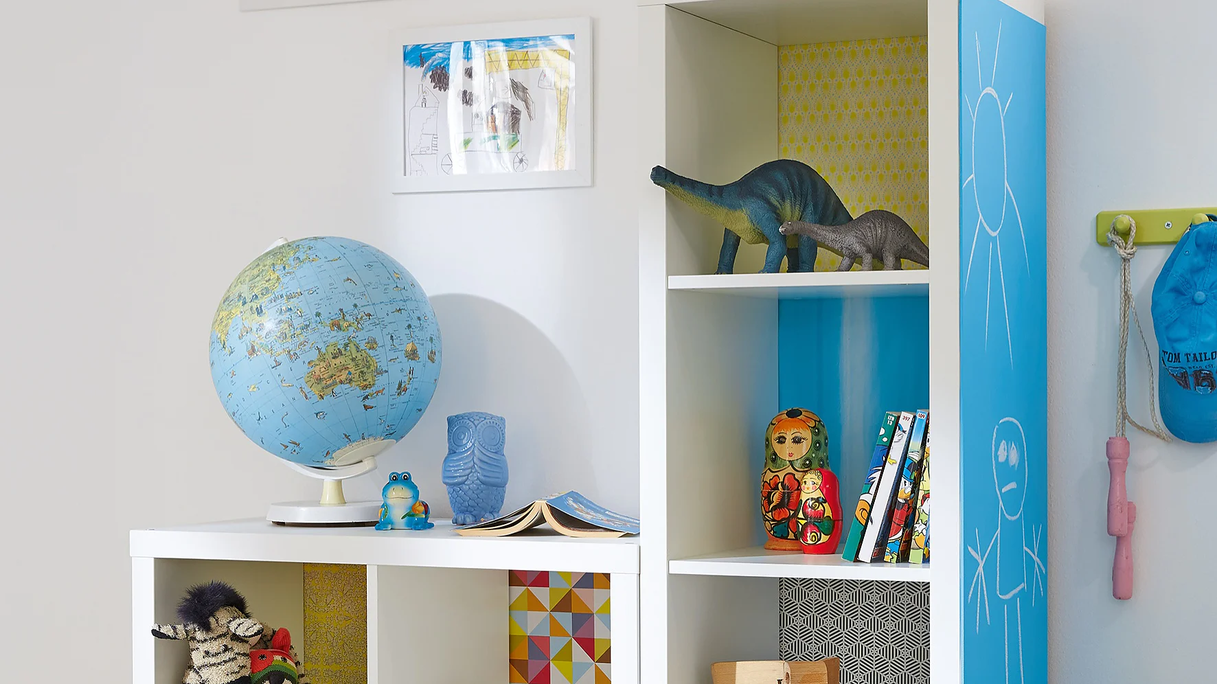 Here's an idea that kids will love. Each shelf has its own background, using decorative paper, stuck with tesa® Spray Glue PERMANENT, and on the side of the unit, there's a big blackboard so they're free to write or paint.