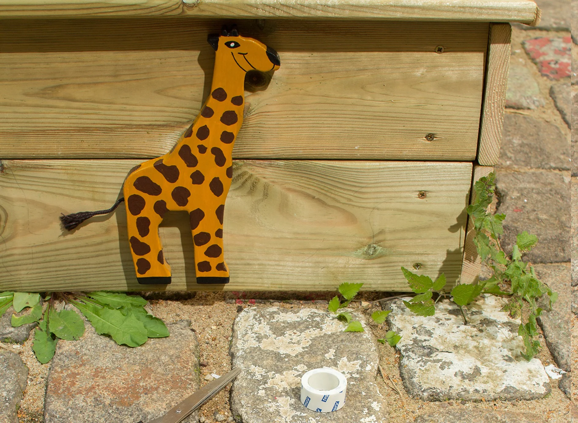 tesa Powerbond® OUTDOOR adhesive tape plus wooden animal applied to sandbox.