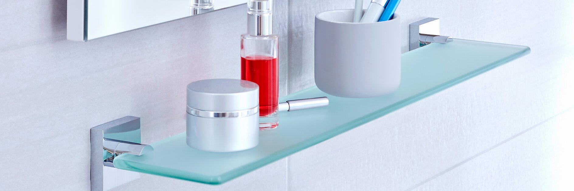 Utilisez l’espace en dessous de votre miroir de salle de bains en installant une élégante tablette en verre au mur.