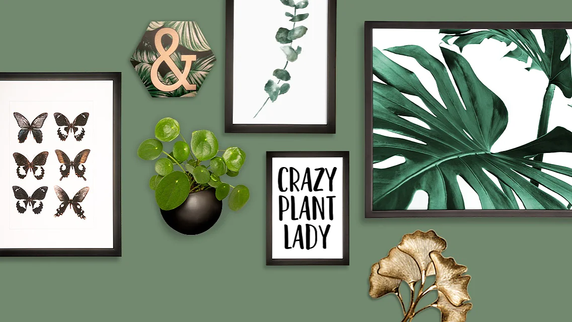 A wall with a green background features framed art: black butterflies, eucalyptus leaves, a large leaf, and a sign reading Crazy Plant Lady. Theres also a gold ampersand and a small potted plant. The frames are securely mounted using tesa tape for an impeccable finish. (This text has been generated by AI)