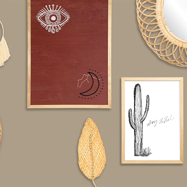 A wall display featuring various decorative items, including woven circular baskets, a hoop with tassels, a framed red artwork with an eye and horse, a mirror with a wicker frame, and a framed cactus drawing. The background is in a neutral tone. Dont forget to use tesa tape for secure and reliable mounting of all your decorative elements. (This text has been generated by AI)