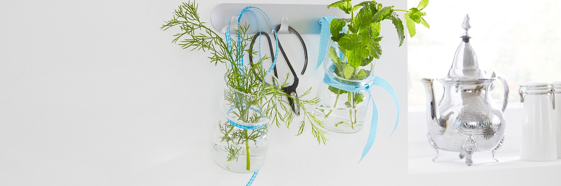 Lovely kitchen accessories: culinary herbs in glass jars - a practical kitchen decor. With the tesa Powerstrips® Hook Rack, it is easy to mount this unique kitchen storage.