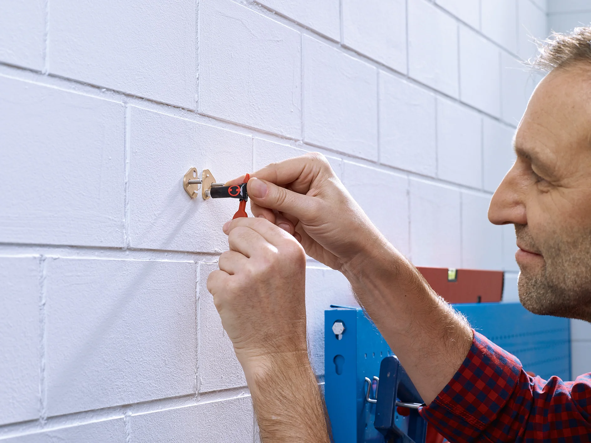 Applying the adhesive to the tesa® Adhesive Screw Triangular for Brick & Stone 2.5kg