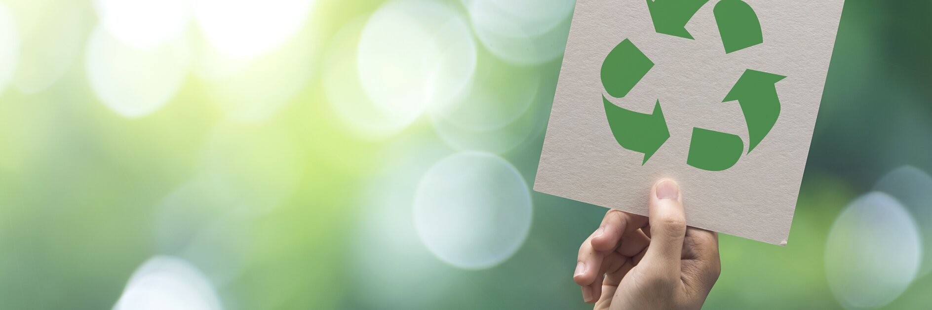 Hand holding recycle symbol on green bokeh background. eco and save the earth concept.