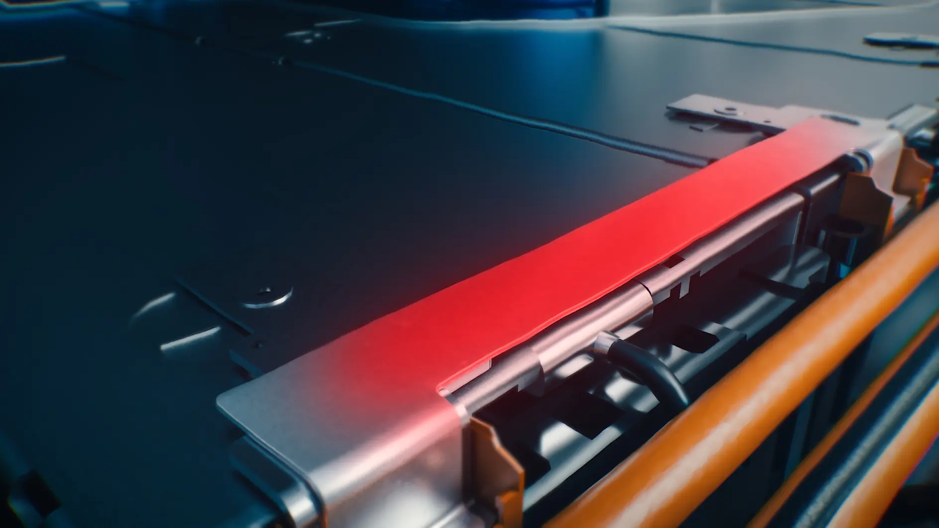 Gros plan sur un composant métallique avec une bande de ruban tesa rouge, probablement une partie d'une batterie ou d'un équipement pour véhicule électrique, avec des fils et des connecteurs visibles.