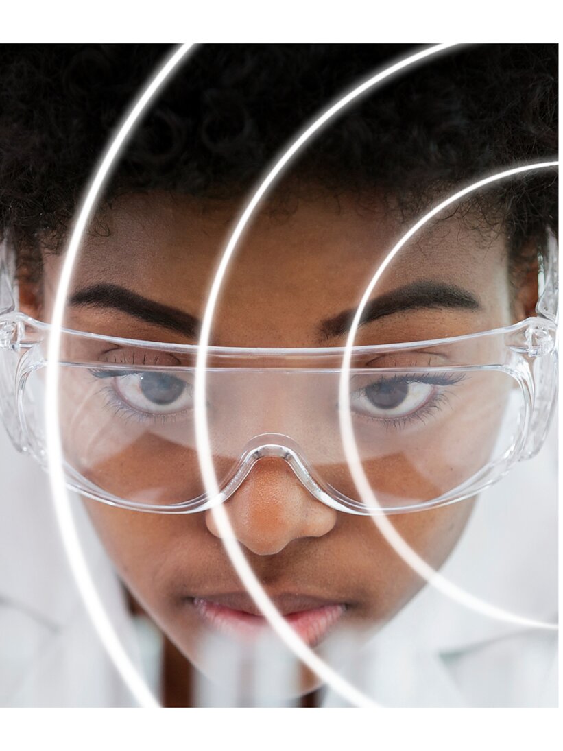 A person wearing clear safety goggles is seen in close-up, with their face partially obscured by concentric circular white lines made of tesa tape. They have short curly hair and a focused expression. The background is white, and the image has a futuristic feel. (This text has been generated by AI)