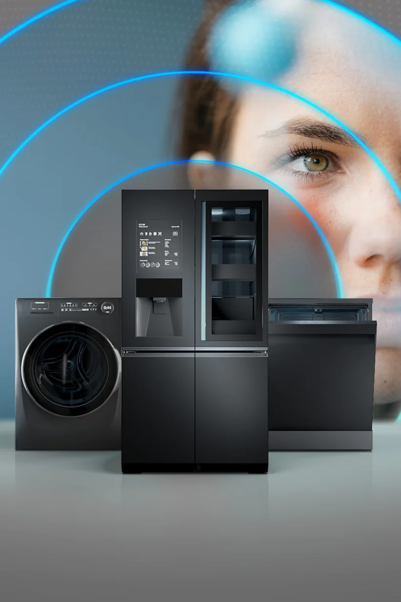 A washing machine, refrigerator, and dishwasher are displayed in the foreground. In the background, a womans face is partially visible, with blue concentric circles emanating from the appliances, suggesting connectivity or technology. (This text has been generated by AI)