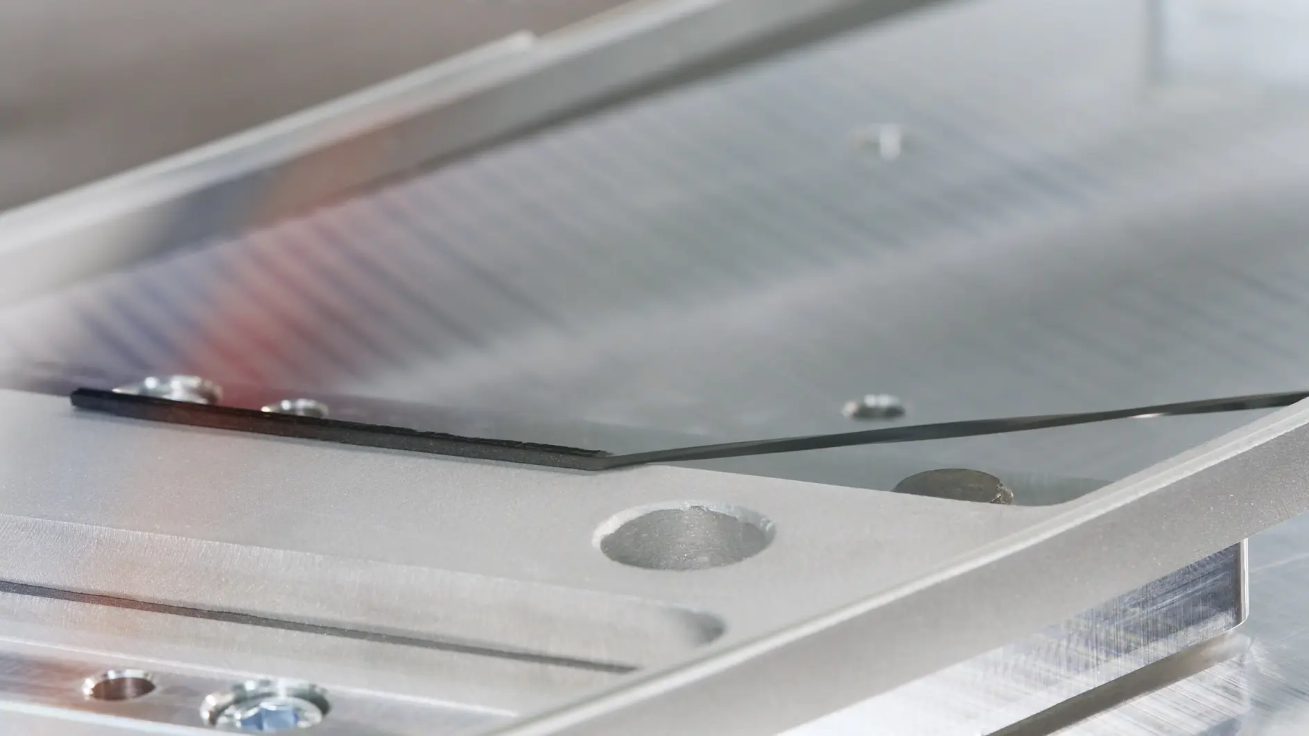 tesa branded transparent adhesive tape on a clear plastic surface in a close-up indoor setting