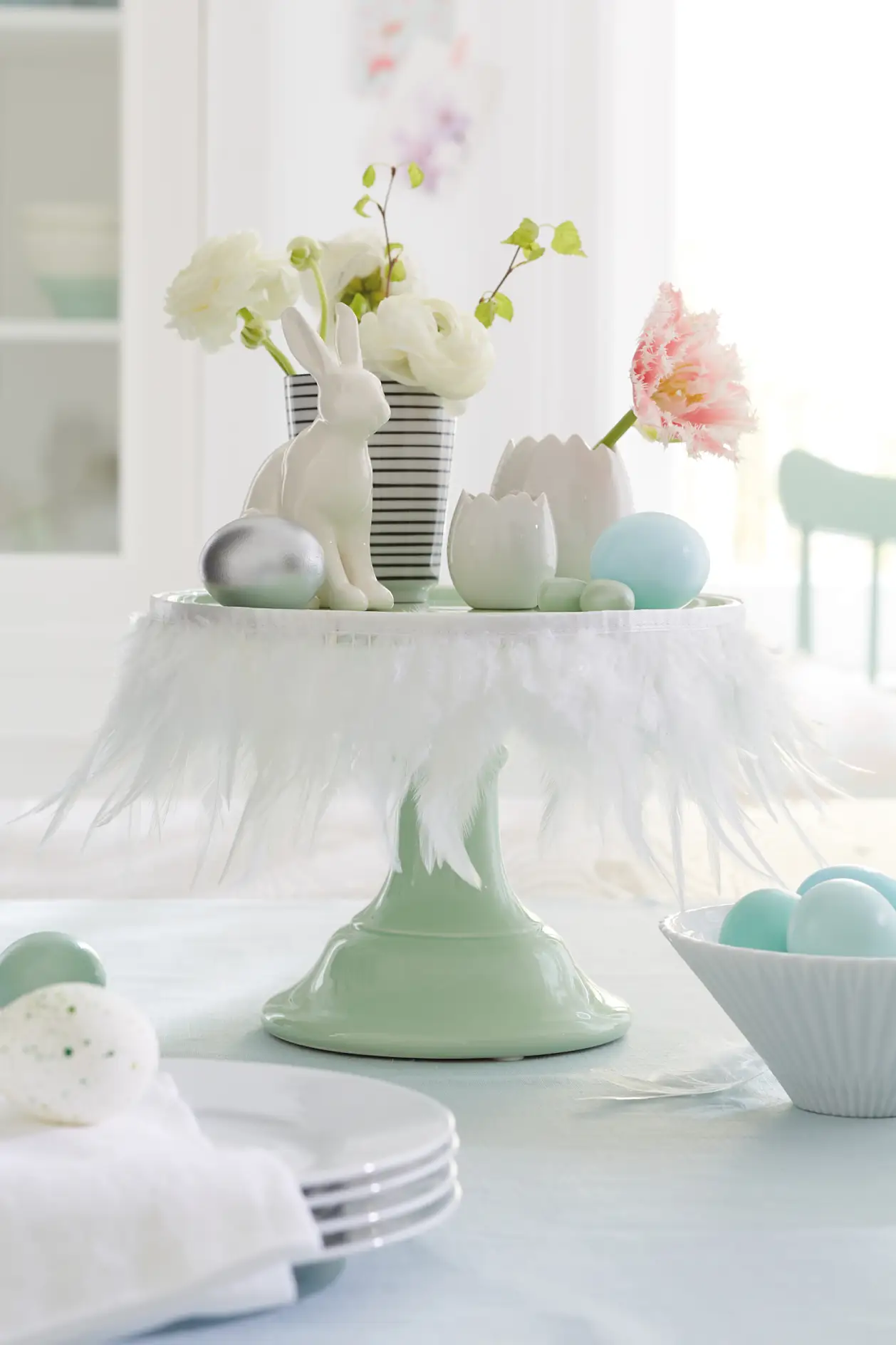 White feathers transform a cake stand into a Easter stage for bunnies, flowers and eggs. The secret weapon for this quick decoration idea: tesa® double-sided adhesive tape.