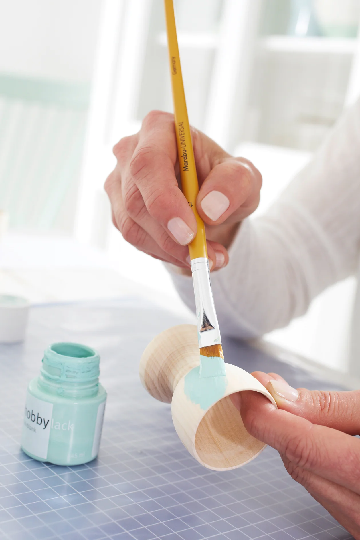 Paint the wooden egg cups with acrylic paint in different colors and allow to dry completely.