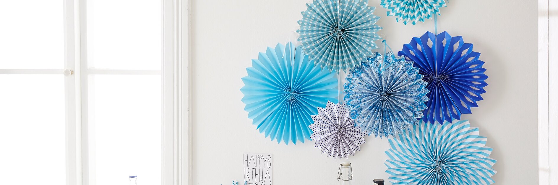 Interior decorating: The birthday party decorations "paper rosettes" are easily mounted with the picture hangers tesa Powerstrips® Transparent DECO Hooks.