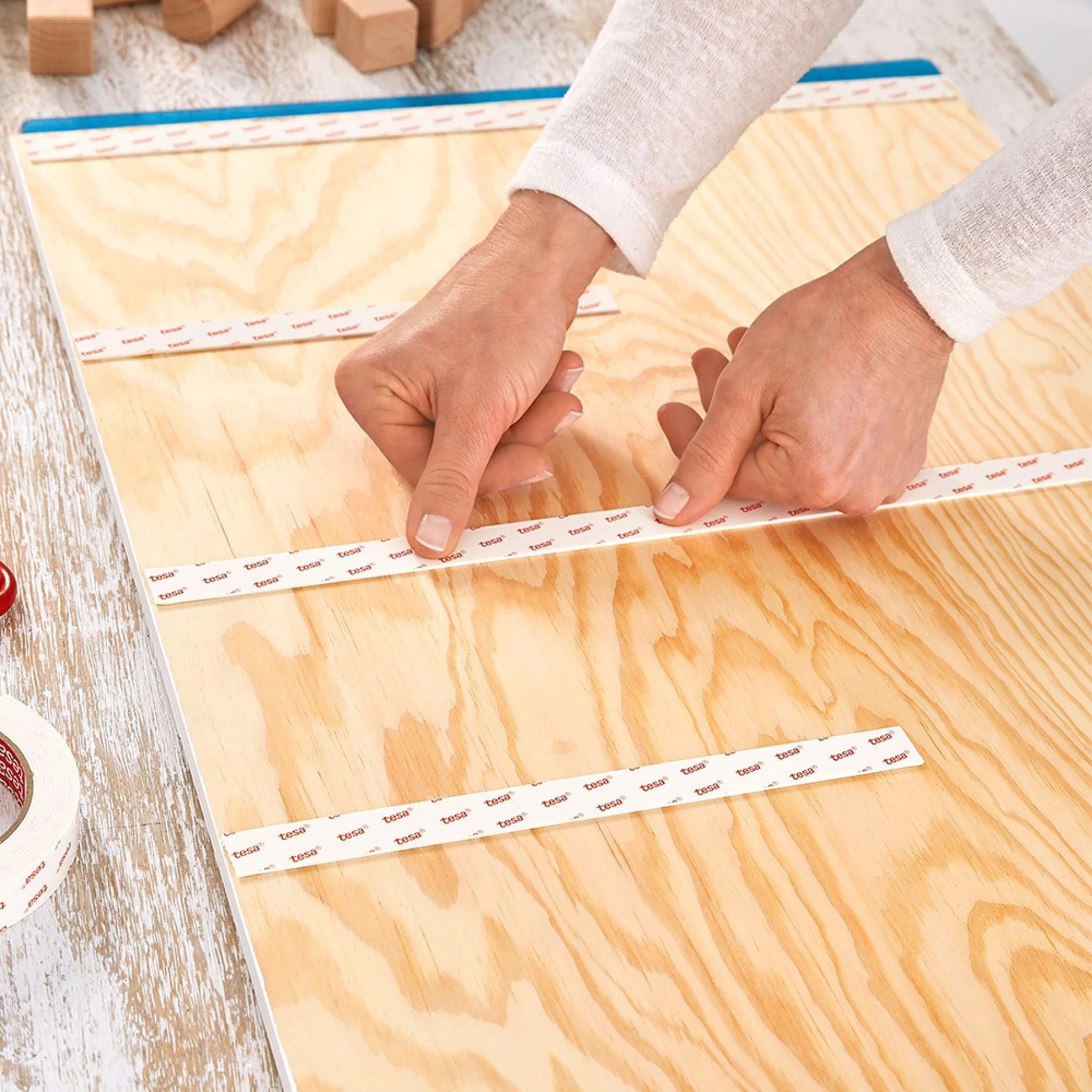 Applying mounting tape for wallpaper & plaster when making key holder for the wall.