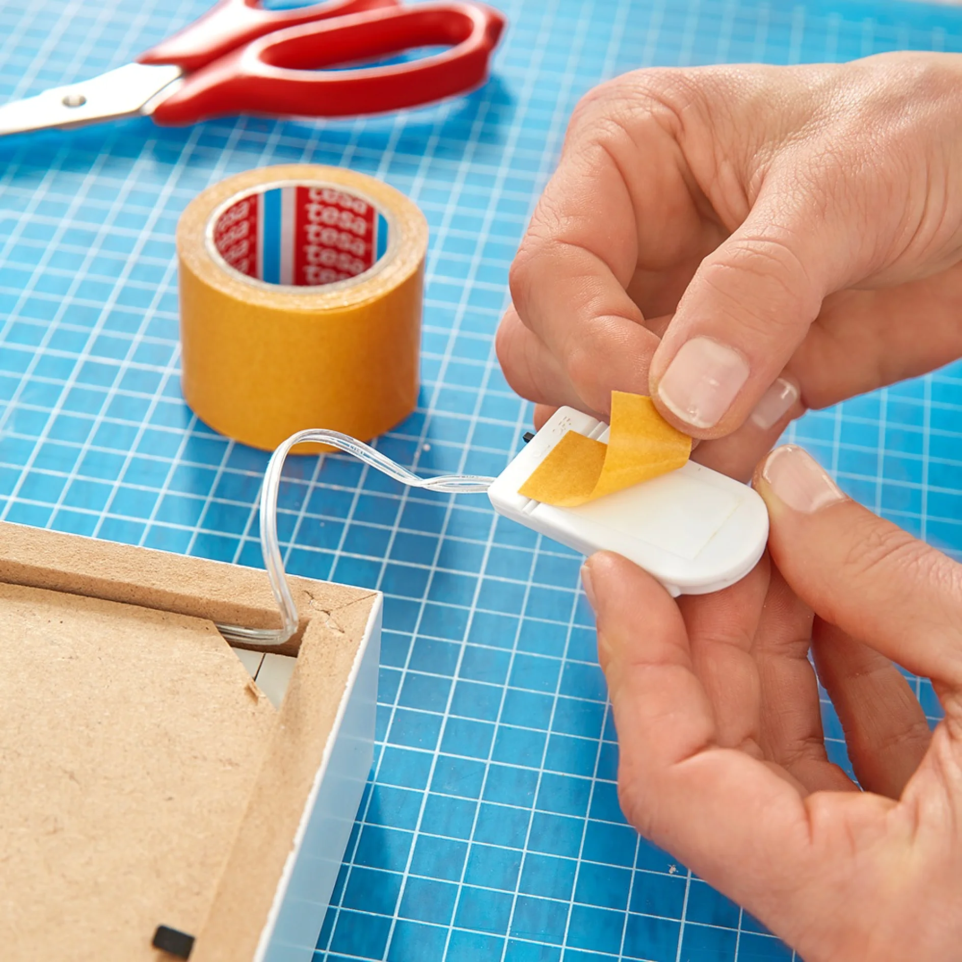 Using handicrafts tape when making a picture frame wall light.