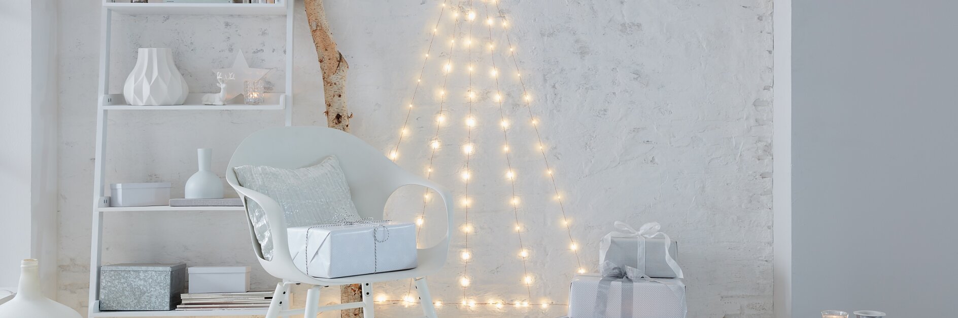 Needleless and extremely low-maintenance: A Christmas tree that doesn't need decorations. Create the tree with LED fairy lights that are fixed to the wall with transparent hooks.