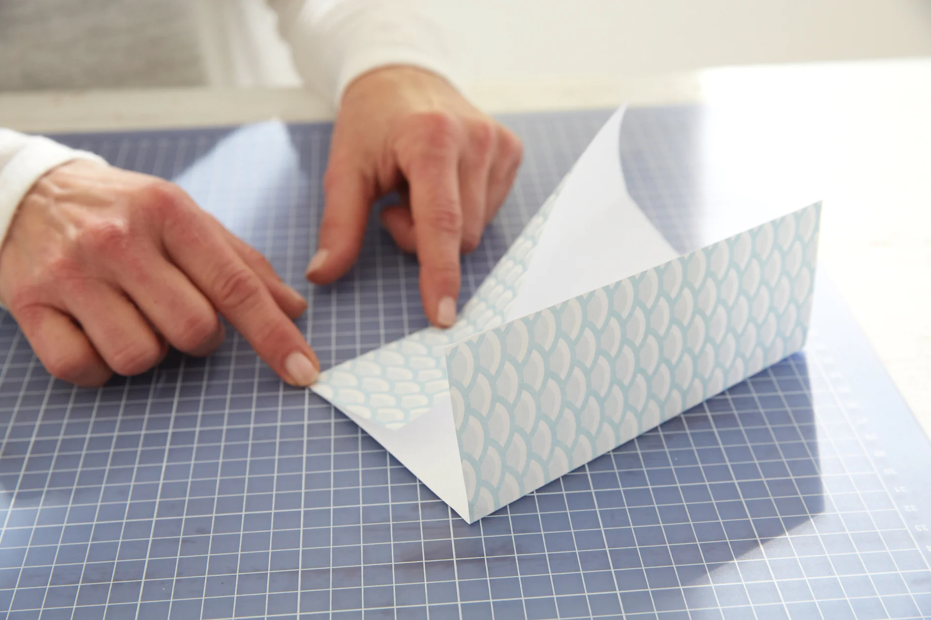 Cut 17 x 24 cm rectangles from the patterned papers and fold both 17-cm sides 6.5 cm inwards.