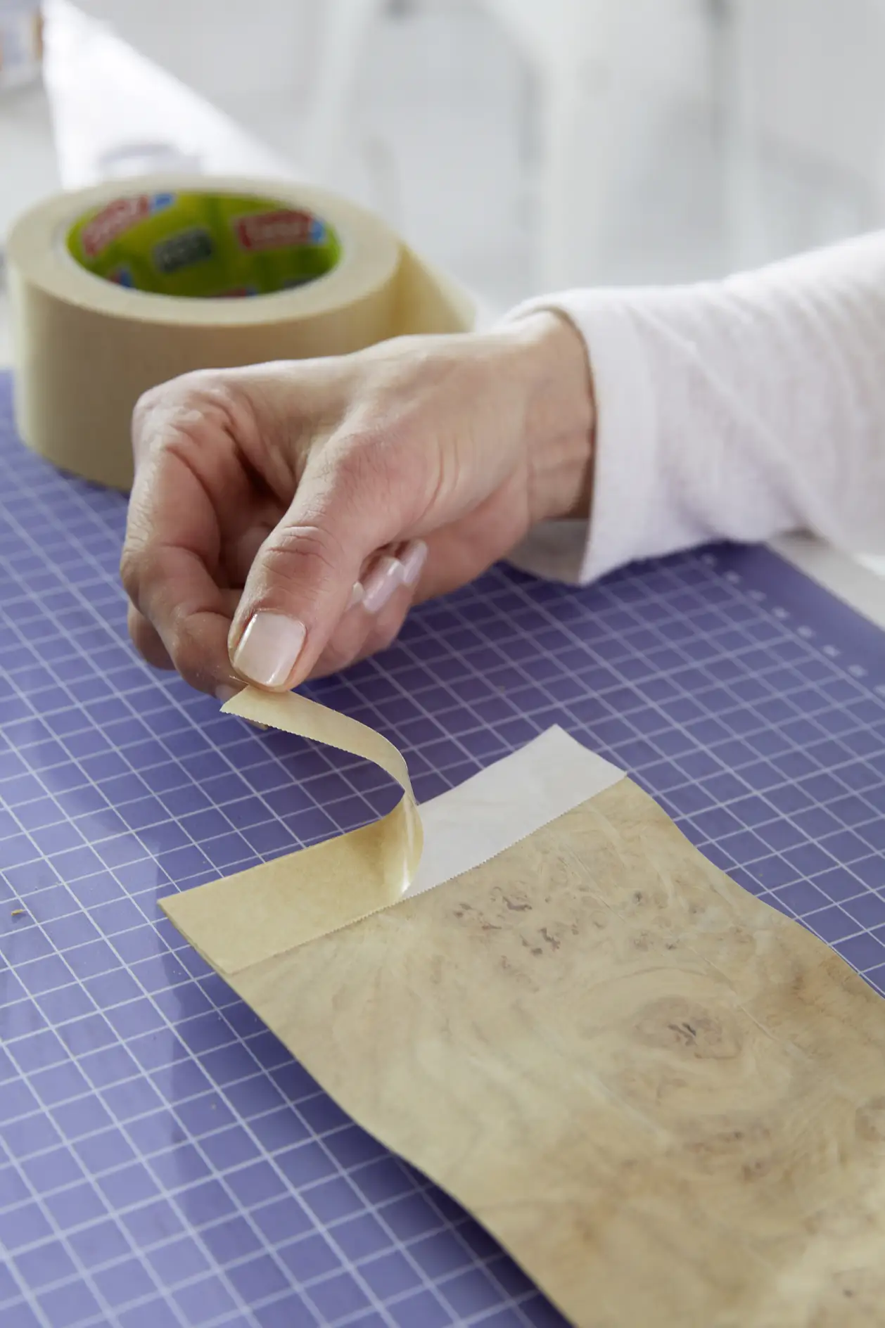 Cut a strip of double-sided tape, then stick it to one side.
