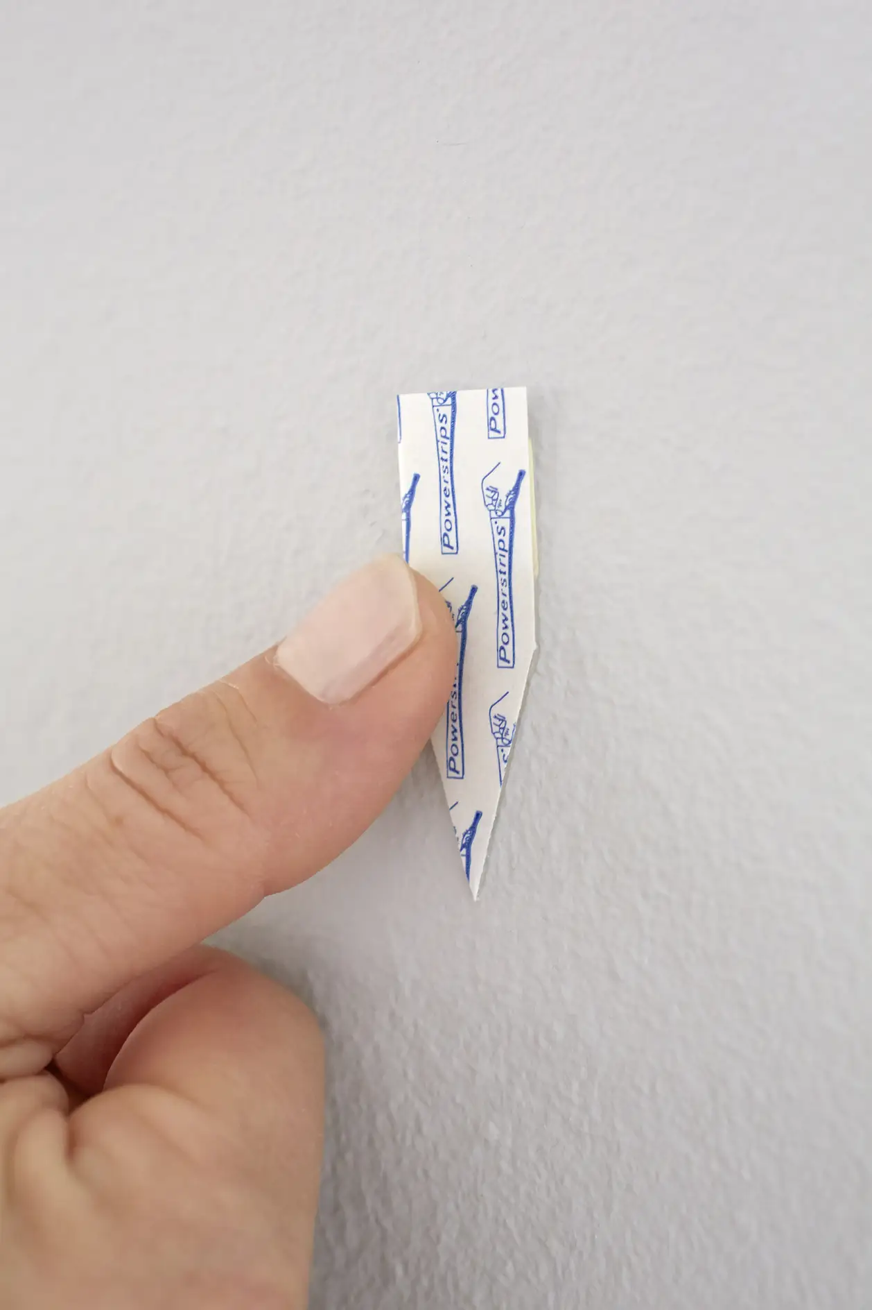 Peel off the tesa Powerstrips® and push them firmly for five seconds to the wall in the desired location.