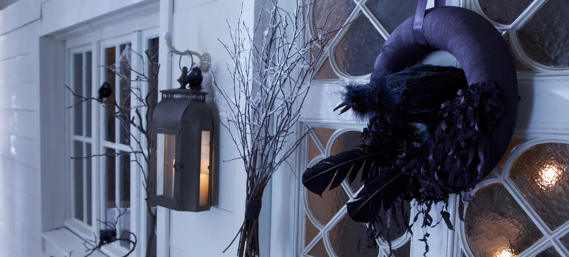 A black raven in its nest is guarding the door on Halloween.