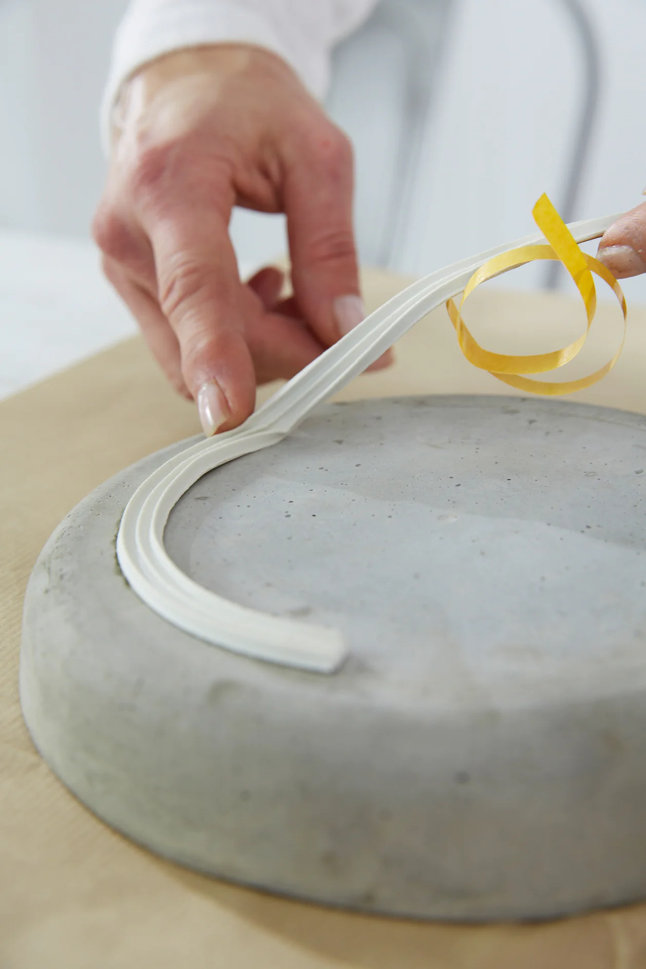 Fixing a strip of tesamoll® E-Profile to the bottom of the bowl.