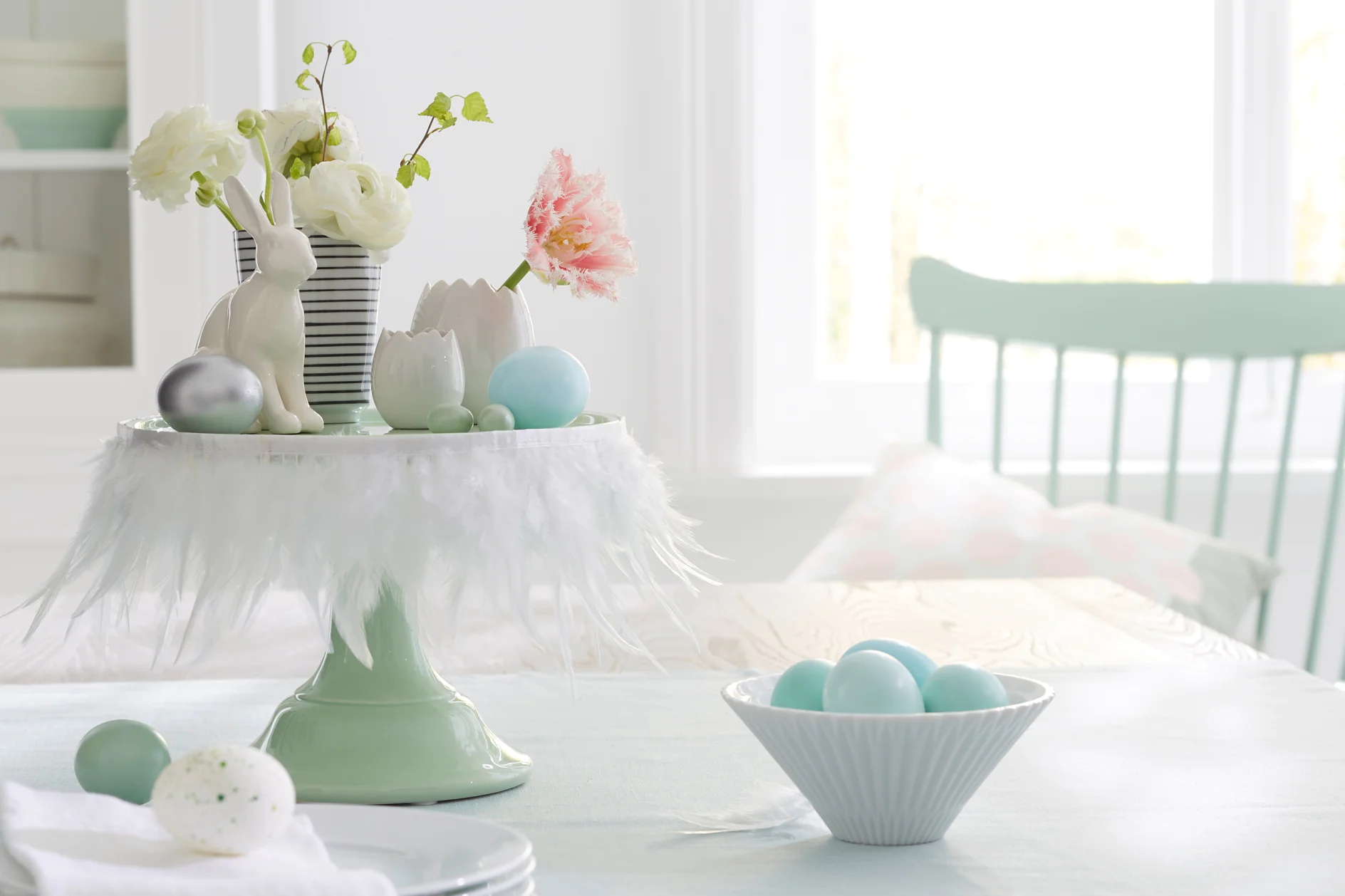 White feathers transform a cake stand into a Easter stage for bunnies, flowers and eggs. The secret weapon for this quick decoration idea: tesa® double-sided adhesive tape.