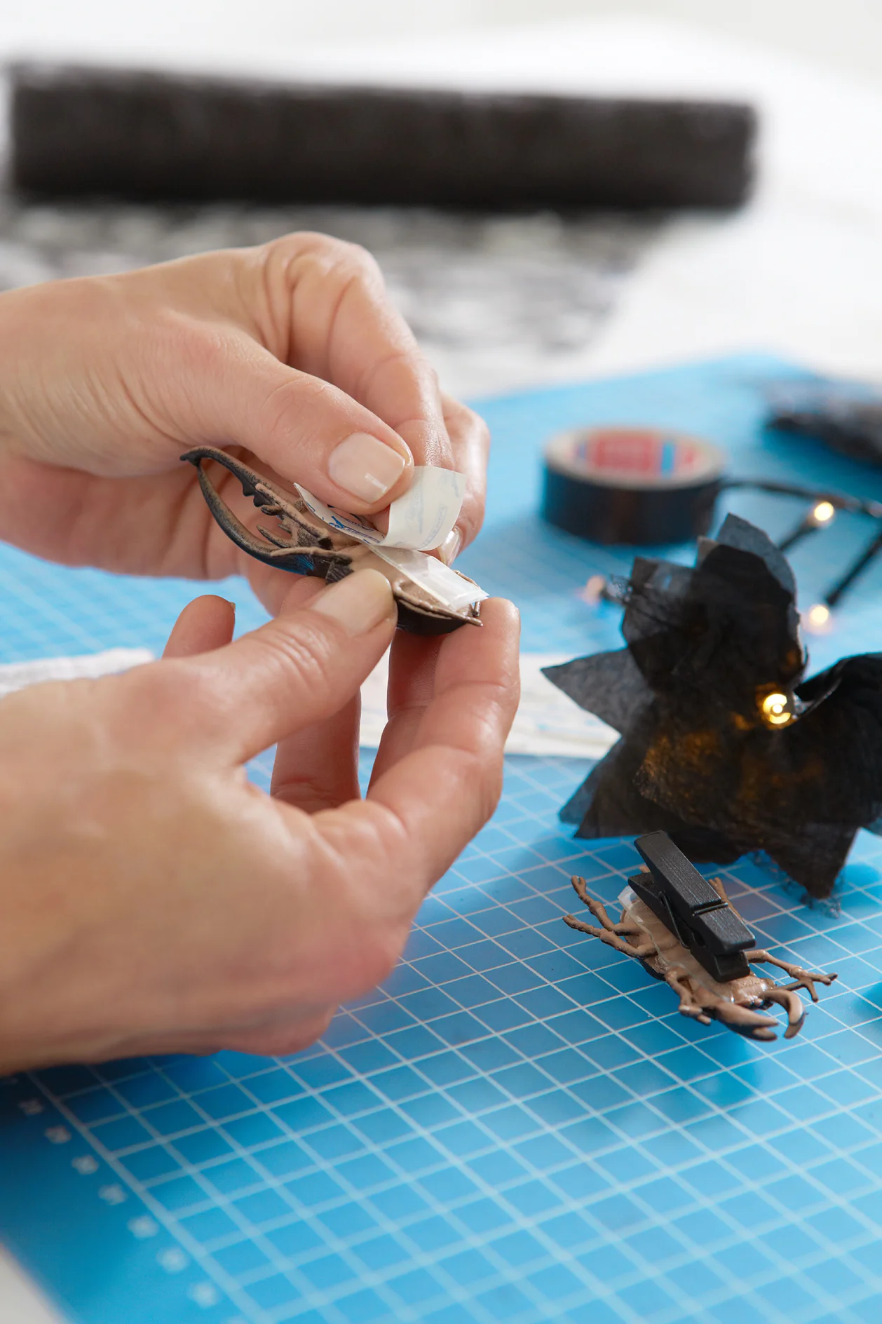 Die Plastikkäfer mit den tesa® Powerstrips Deco auf den Wäscheklammern befestigen und zwischen die Blüten an die Lichterkette klemmen.