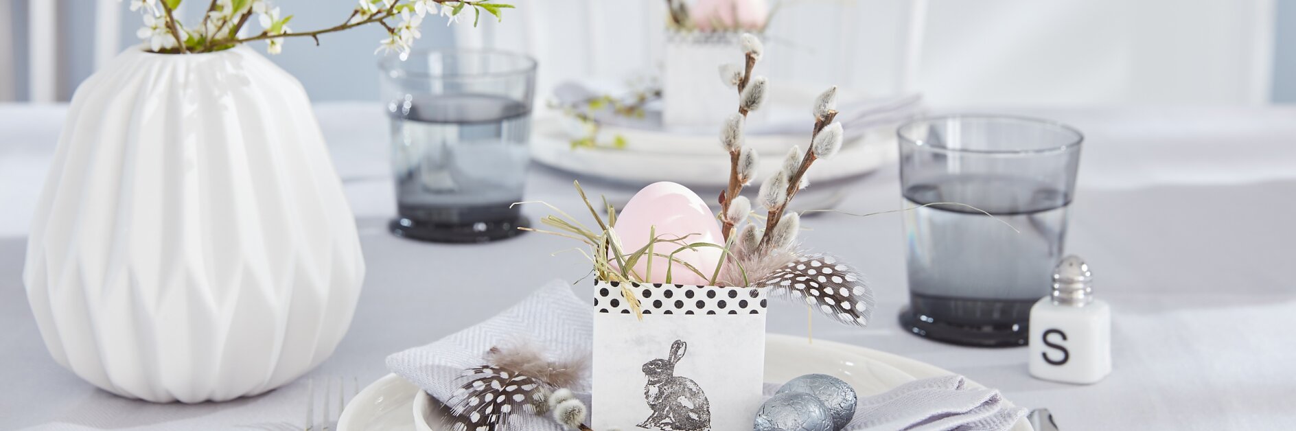 Das selbstgemachte Osternest wird mit etwas Heu, ein paar Ästen und einer Feder zum niedlichen Eierbecher, taugt aber auch gut als Versteck für leckere Süßigkeiten.