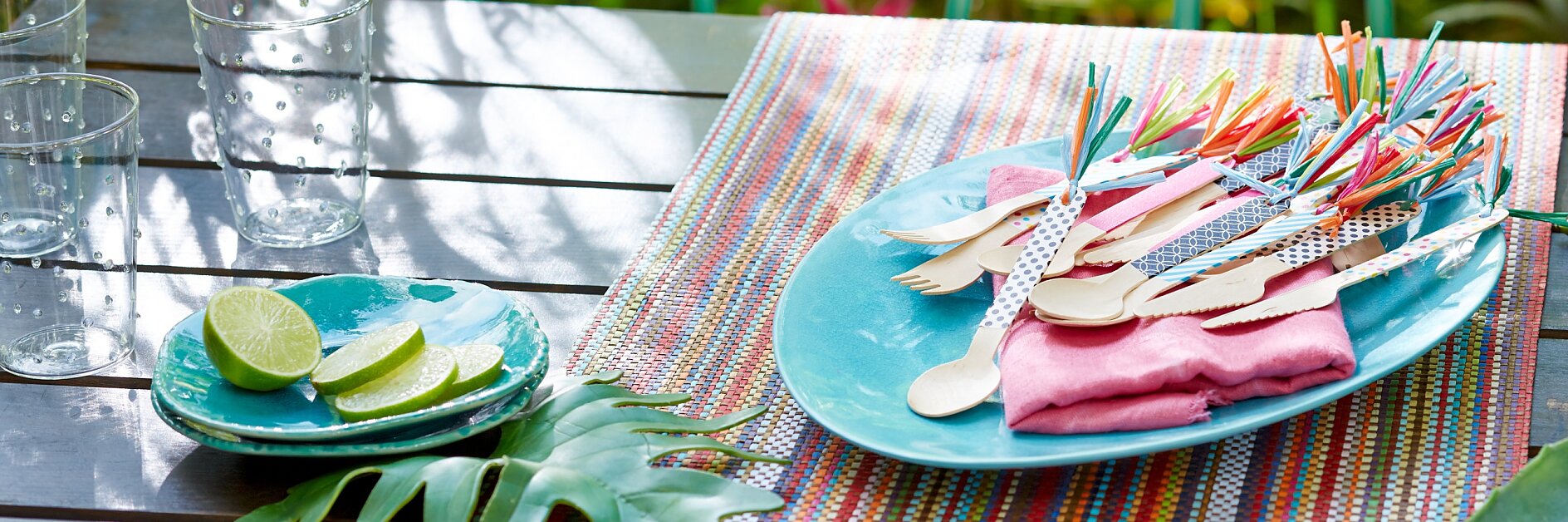 Picknickbesteck aus Holz sieht gewöhnlich recht langweilig aus. Wenn man die Griffe aber mit tesa® Deco Tape beklebt und dann noch mit Bastquasten verziert, sind sie ruck, zuck sommertauglich.