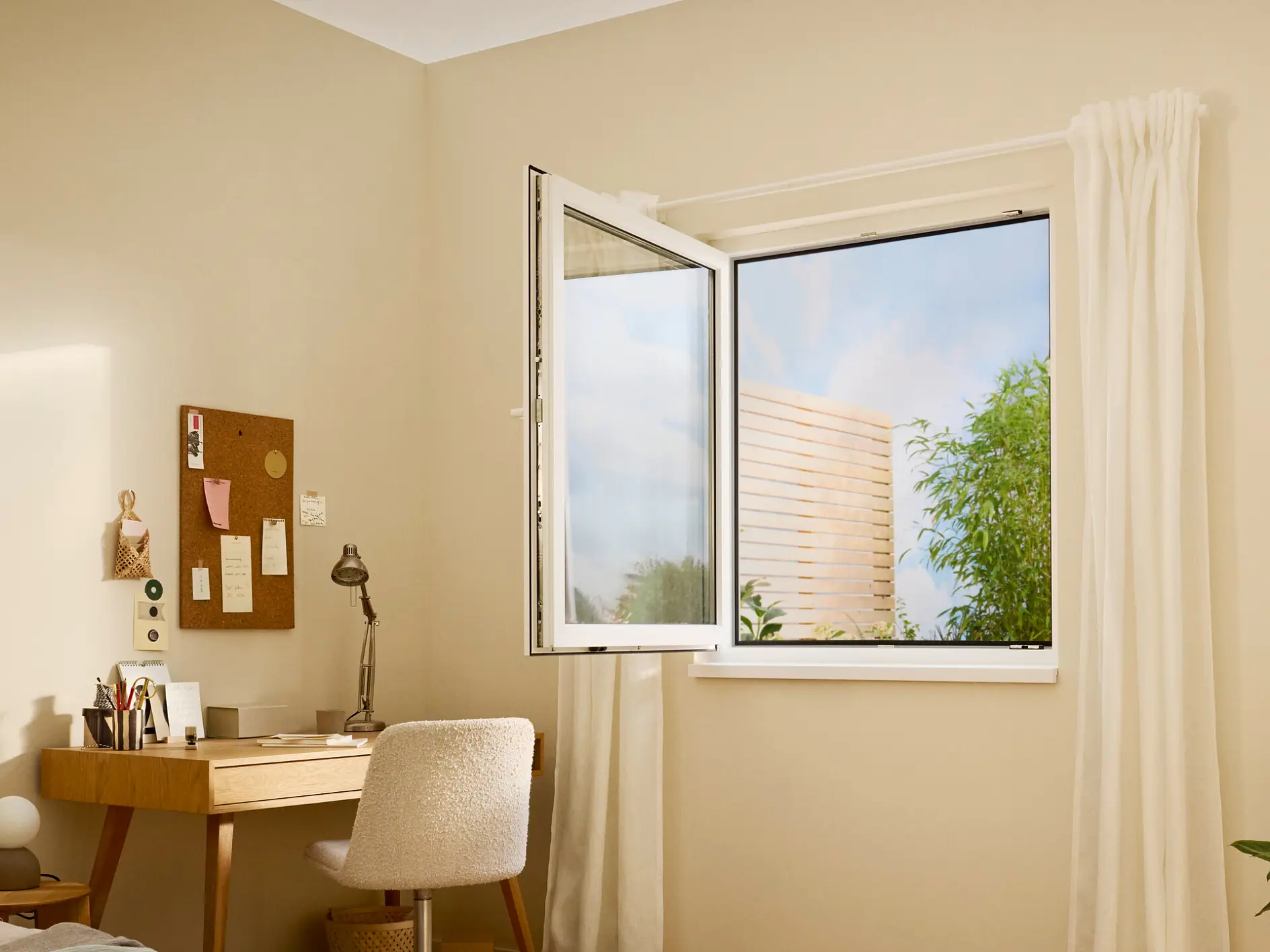bright home office with wooden desk, chair, open window showing greenery outside, and neutral beige walls with minimal decor (This text has been generated by AI)