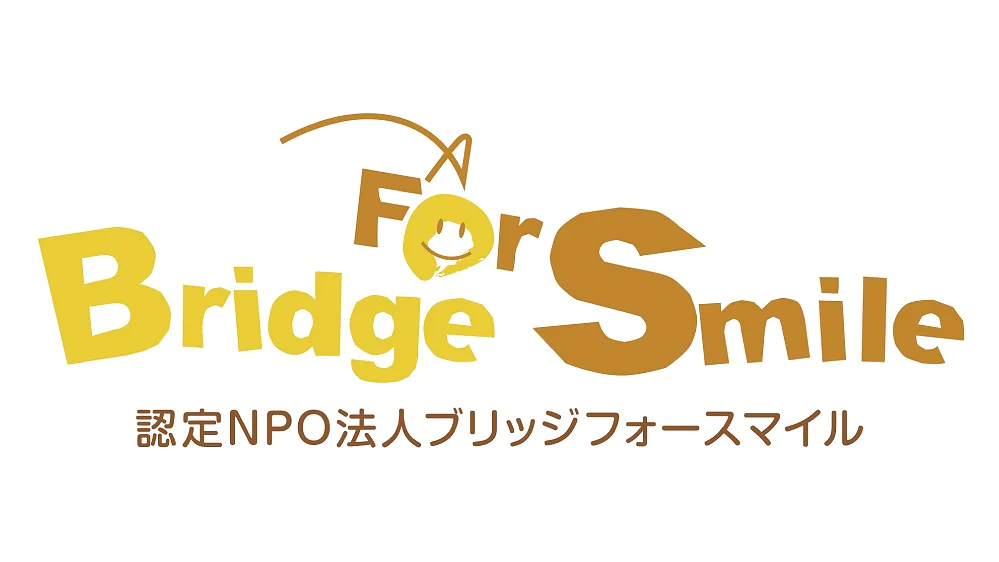 黄色と茶色で「Bridge For Smile」というテキストが入ったロゴ。様式化された橋と笑顔が特徴です。以下の日本語テキストは「認定NPO法人ブリッジフォースマイル」となります。. (This text has been generated by AI)