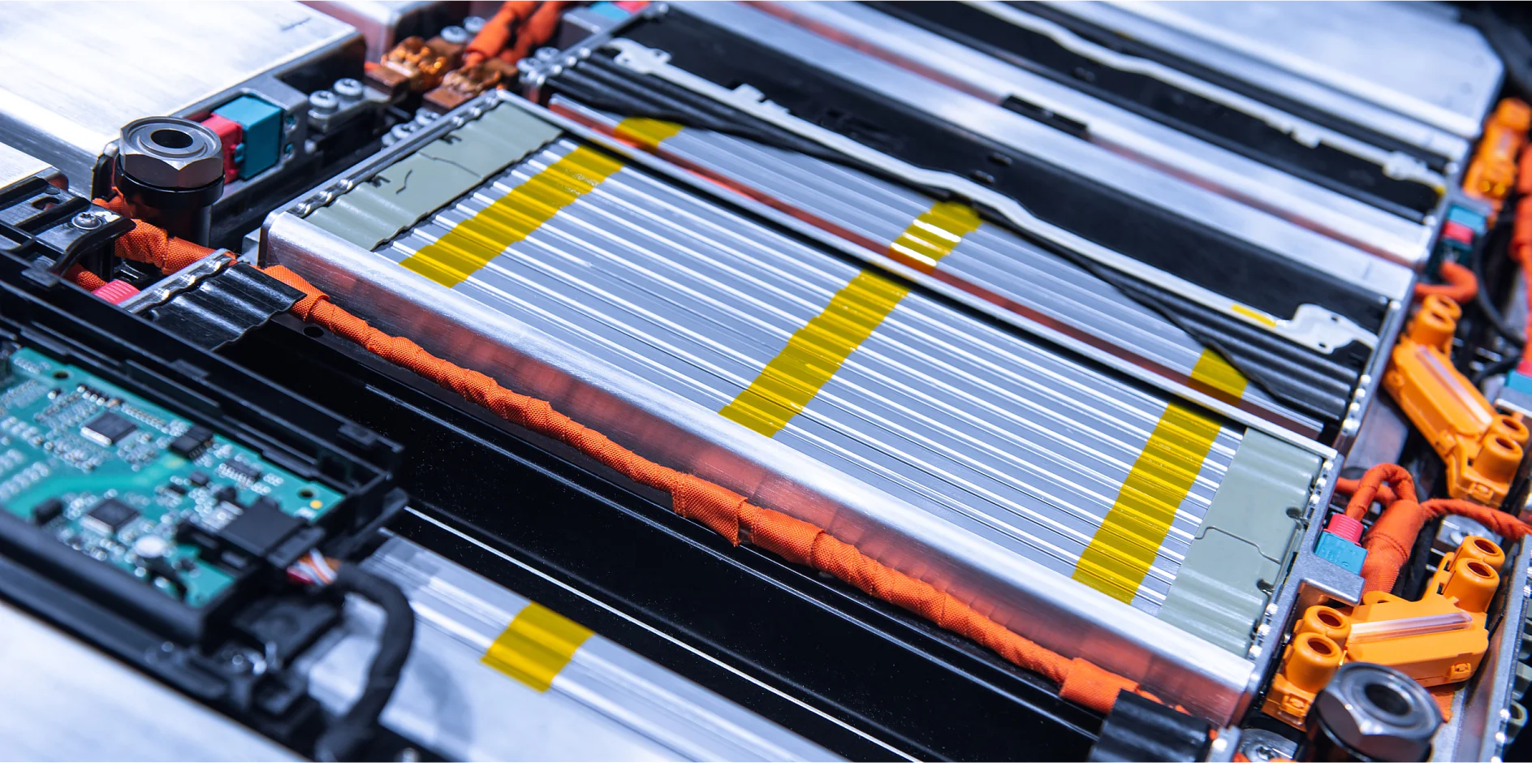 Close-up of a lithium-ion battery pack with exposed metal cells and bright orange electrical connectors. Visible circuit board and yellow safety markings highlight the components within the battery casing, including the use of tesa tape for secure insulation. (This text has been generated by AI)