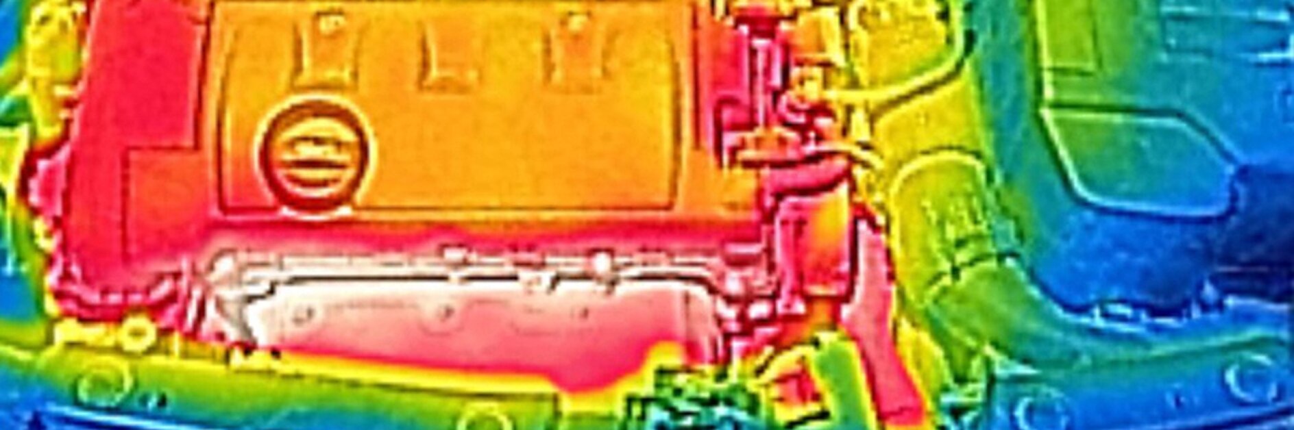 Thermal image of a car engine. The engine appears in warm colors, predominantly red and orange, indicating heat. Cooler colors, such as blue and green, surround the engine, suggesting lower temperatures in those areas. (This text has been generated by AI)