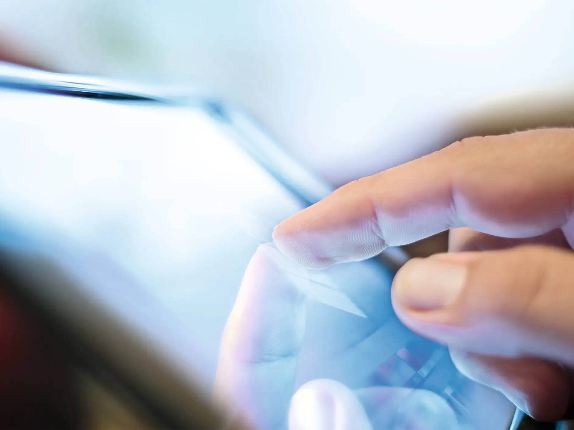 Hand tapping a tablet screen indoors, focusing on the interaction between finger and device display. (This text has been generated by AI)