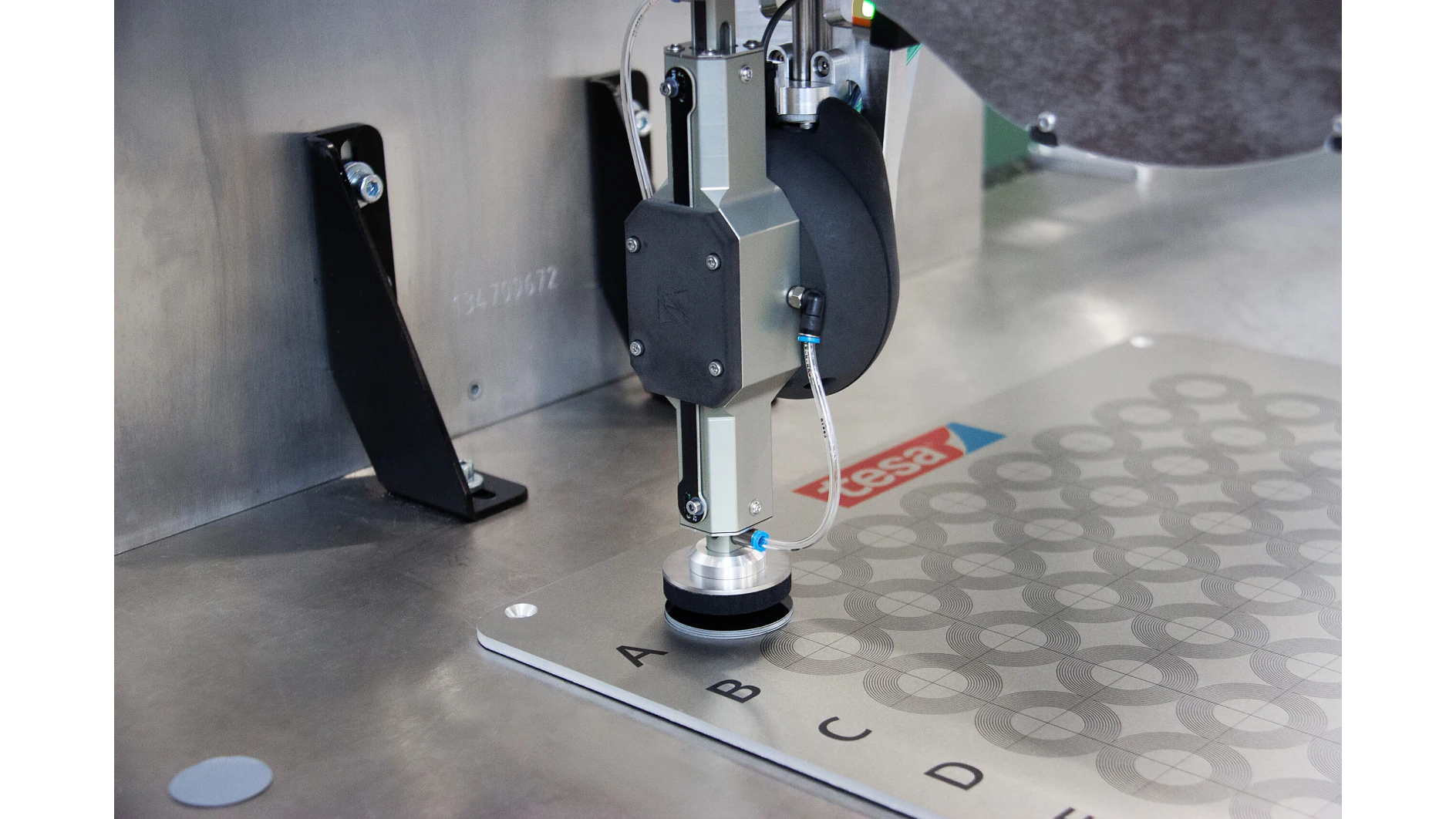 tesa industrial measuring device inspecting circular patterns on a metal surface in a laboratory setting (This text has been generated by AI)