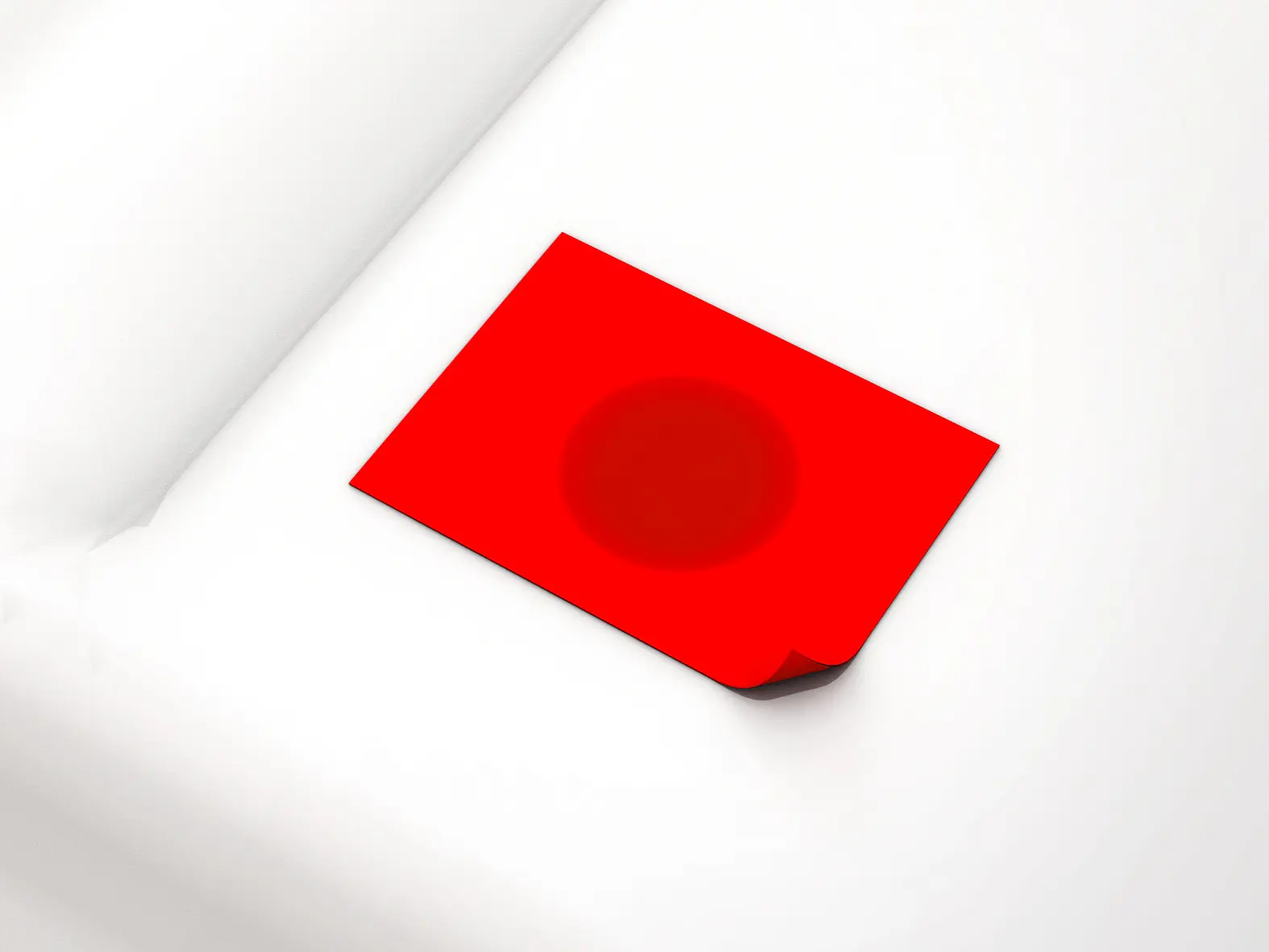 A red rectangular piece of paper or card with a subtle dark circle in the center lies on a white, textured surface. The cards corner is slightly bent upwards, secured by tesa tape. (This text has been generated by AI)