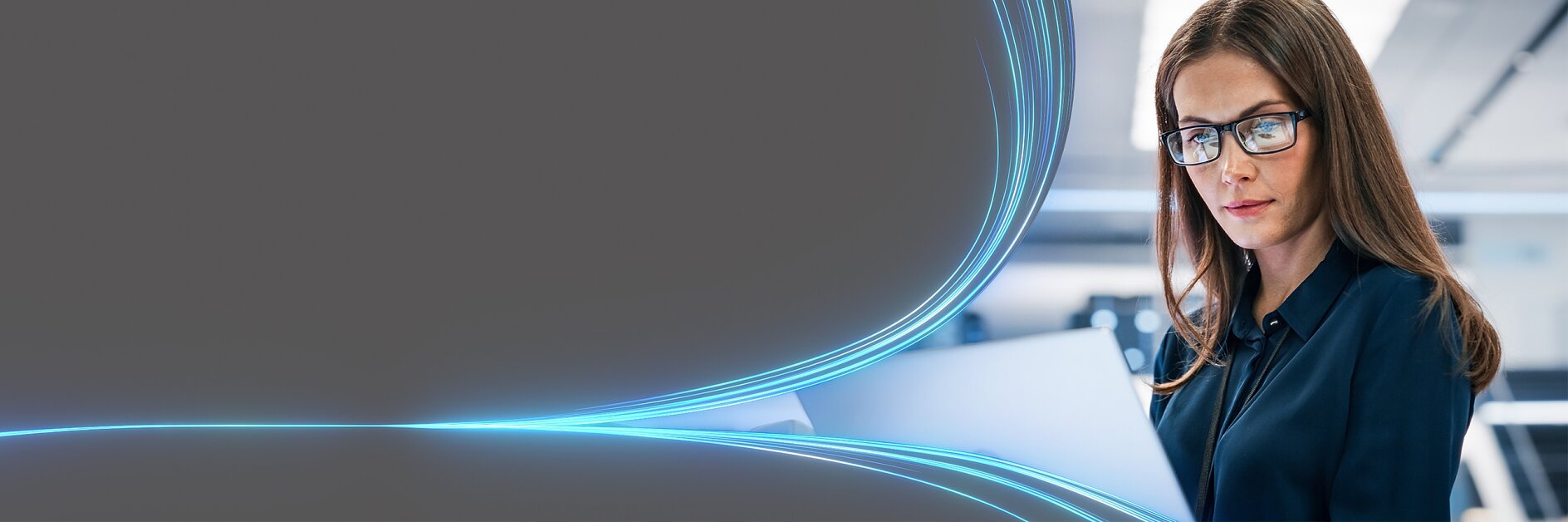 A woman with long brown hair and glasses is looking at an open laptop. She is in a modern, brightly lit office setting. Blue curved light trails are seen on the left side of the image, creating a dynamic visual effect.
