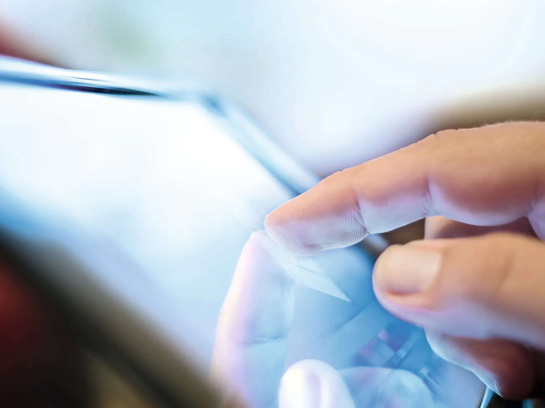 Hand tapping a tablet screen indoors, focusing on the interaction between finger and device display. (This text has been generated by AI)