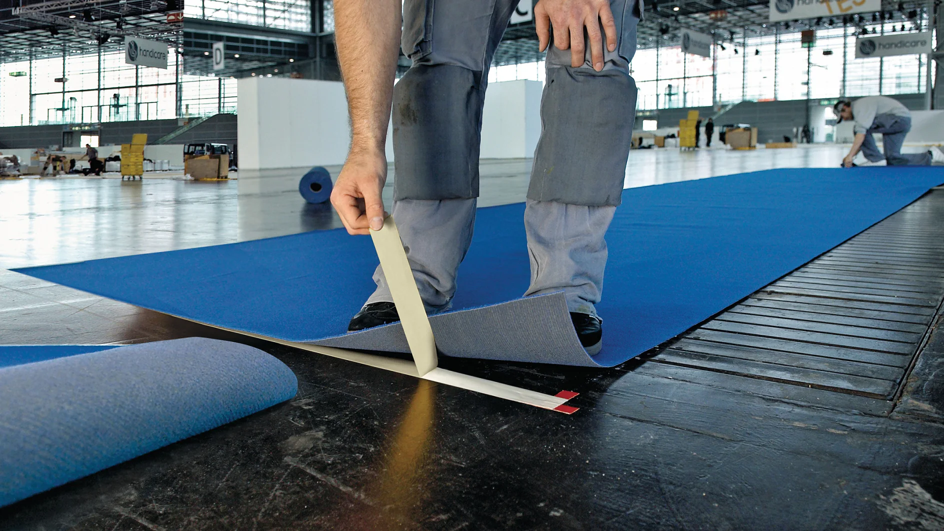 Professional Craftsmen Using Double Sided Floor Laying Tape To Fix Carpet