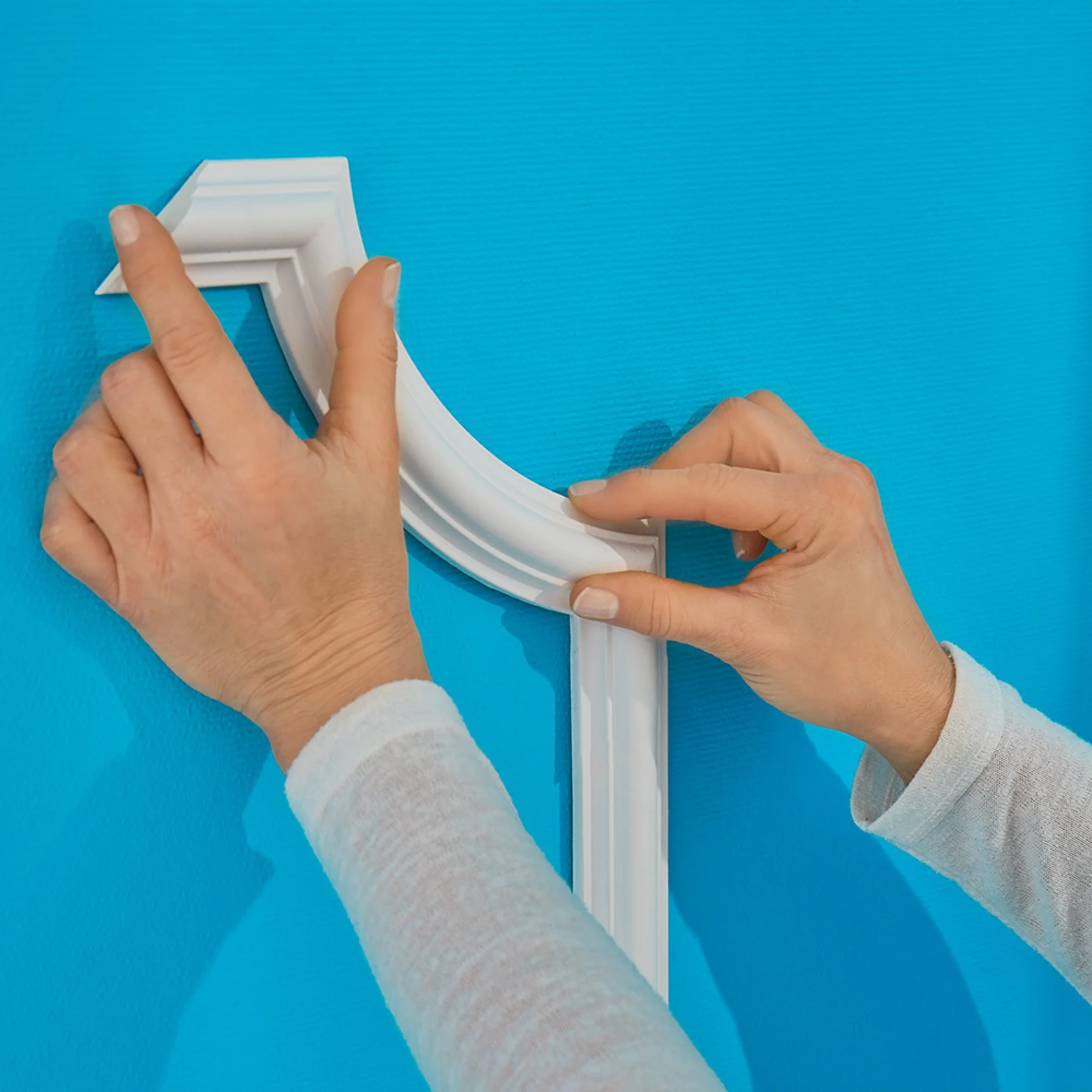 Applying decorative plasterwork to the wall while making a DIY headboard