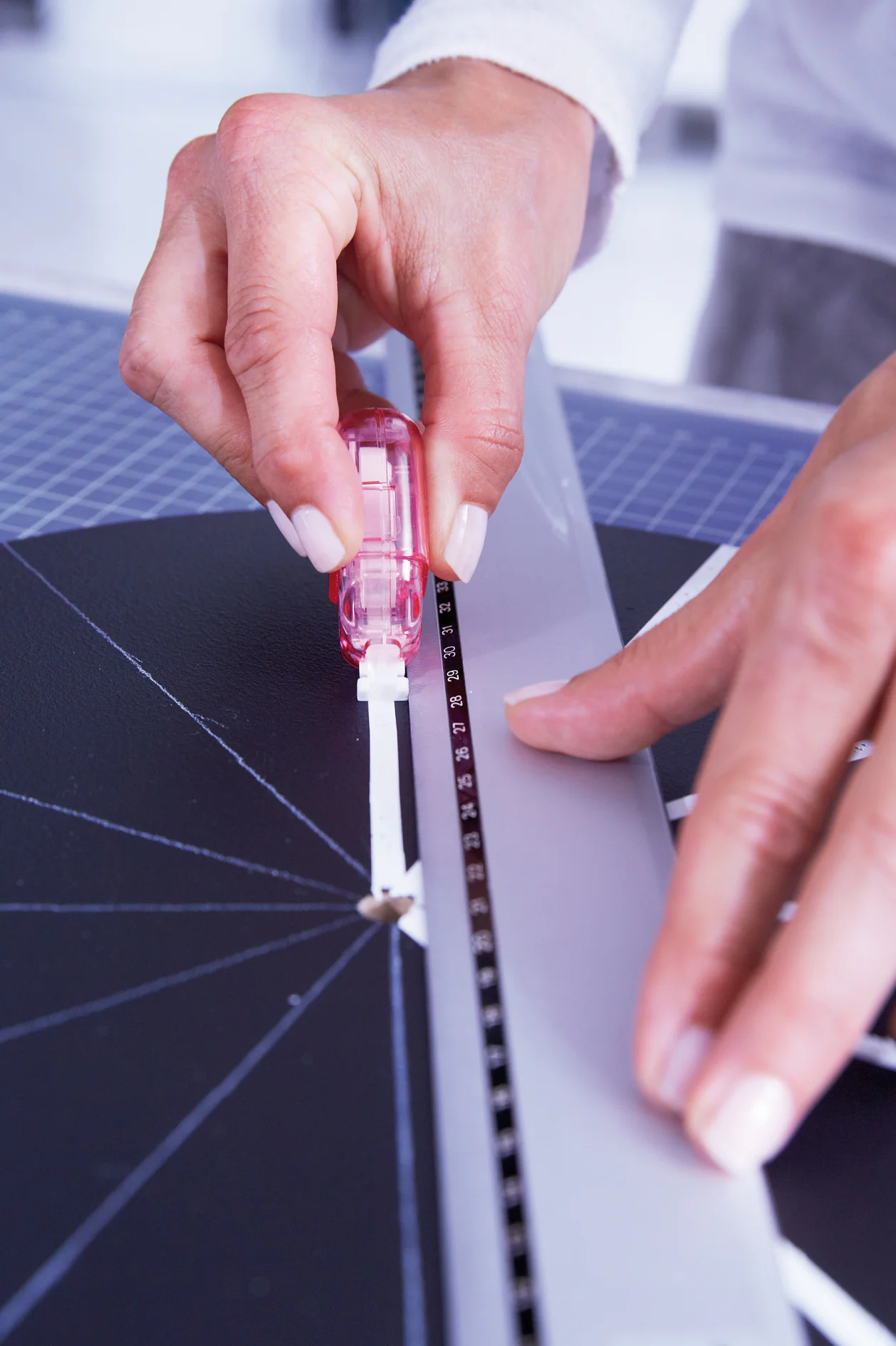 Now position the ruler right next to the line, making sure that the tesa Mini dispenser ecoLogo® is laid out in the center of the drawn line. Now trace the line with the mini dispenser along the ruler starting from the center of the clock. The ruler serves as a guide track; this way you will be able to trace a straight line.