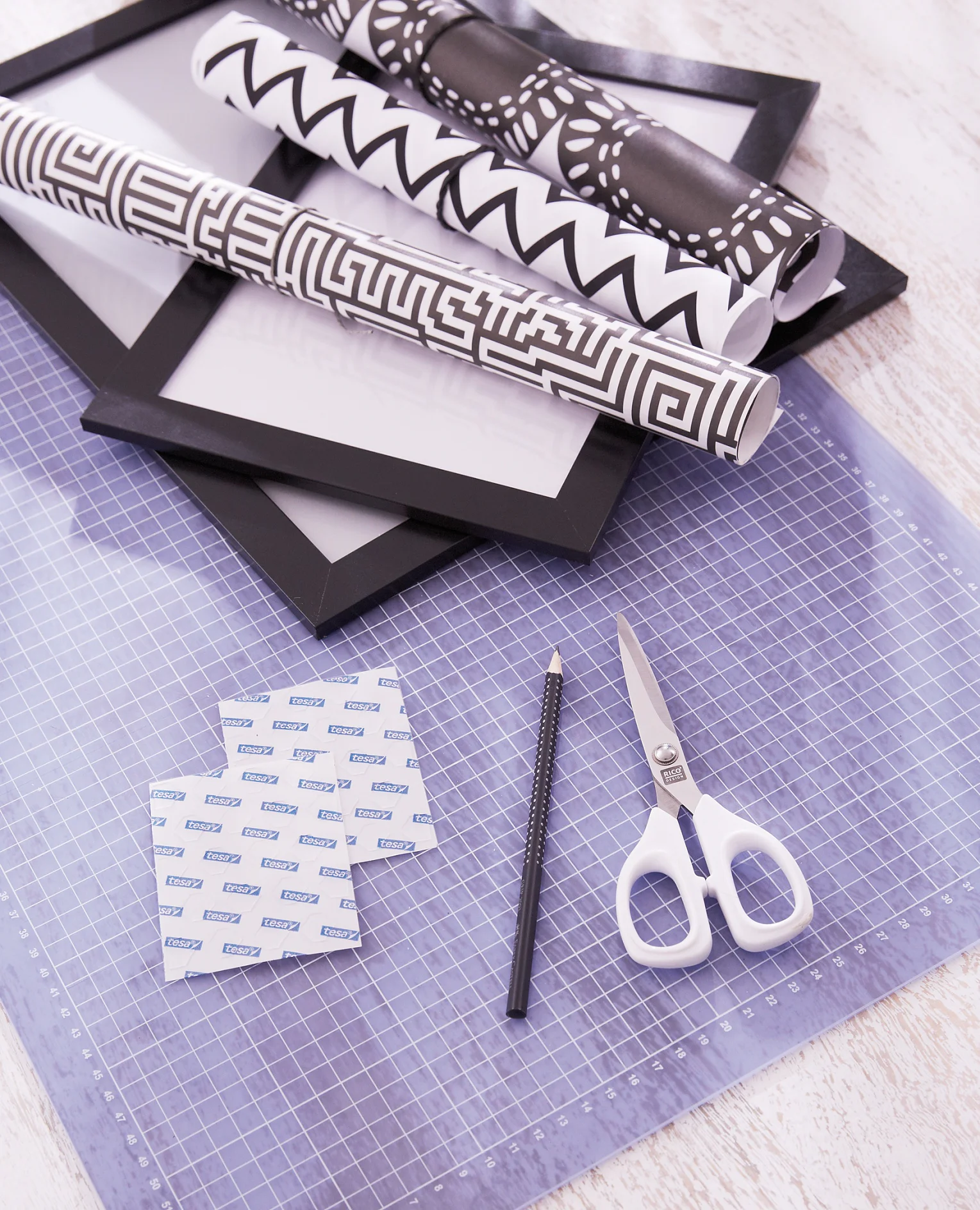 We need:
Black picture frames in different sizes, Black-and-white papers, Scissors, Pencil, tesa TACK® adhesive pads