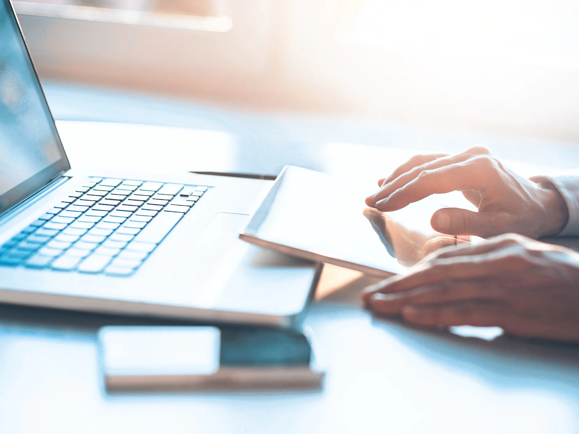 tesa-man-gebruikt-tablet-met-notebook-en-smartphone-op-tafel