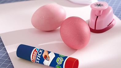 farbowane jajka, dziurkacz ozdobny z motywem kwiatków, nożyczki, kolorowy papier kartonowy, klej w sztyfcie tesa®
