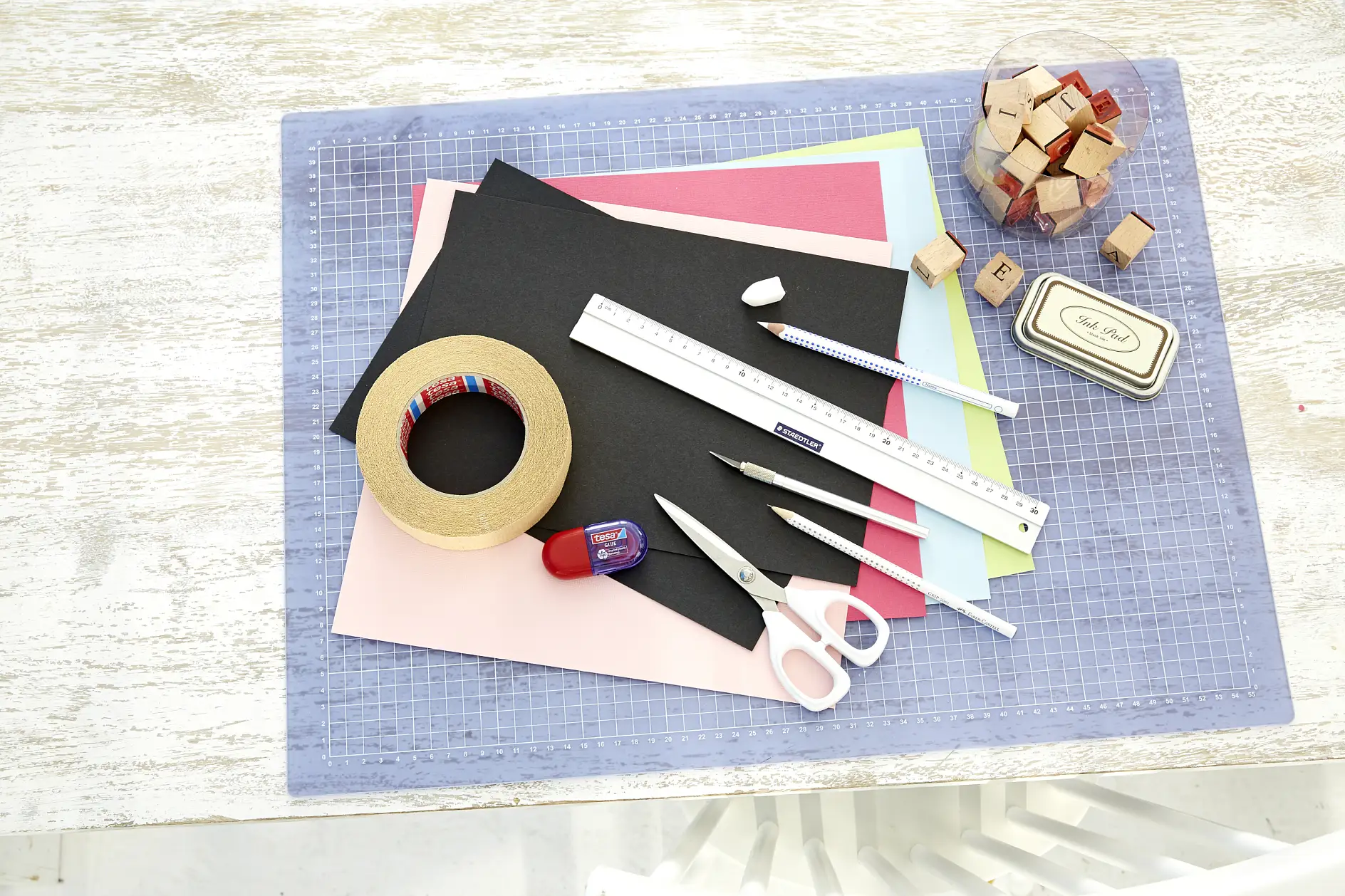 karton A4 w czarnym kolorze, kolorowe kartony, ołówek, linijka, nożyczki, ostry nożyk do wycinania, biała kredka, pieczątka z literkami, poduszka nasączona tuszem, kreda