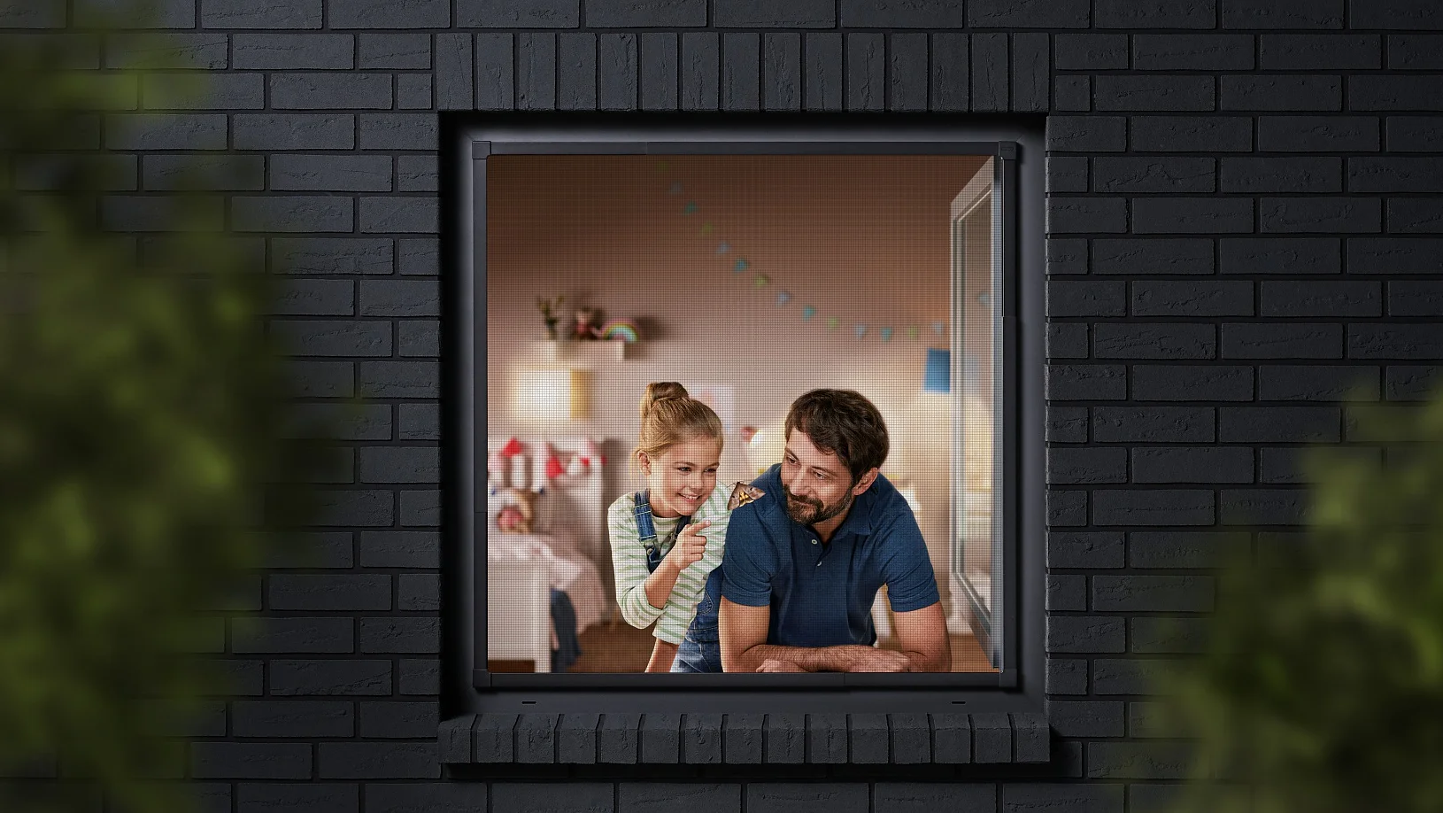 A man and a child are seen through a window, looking into a room decorated with colorful bunting. The building has dark brick walls, and the view is partially framed by blurred greenery. The man is wearing a blue shirt, and the child is sitting beside him. (This text has been generated by AI)