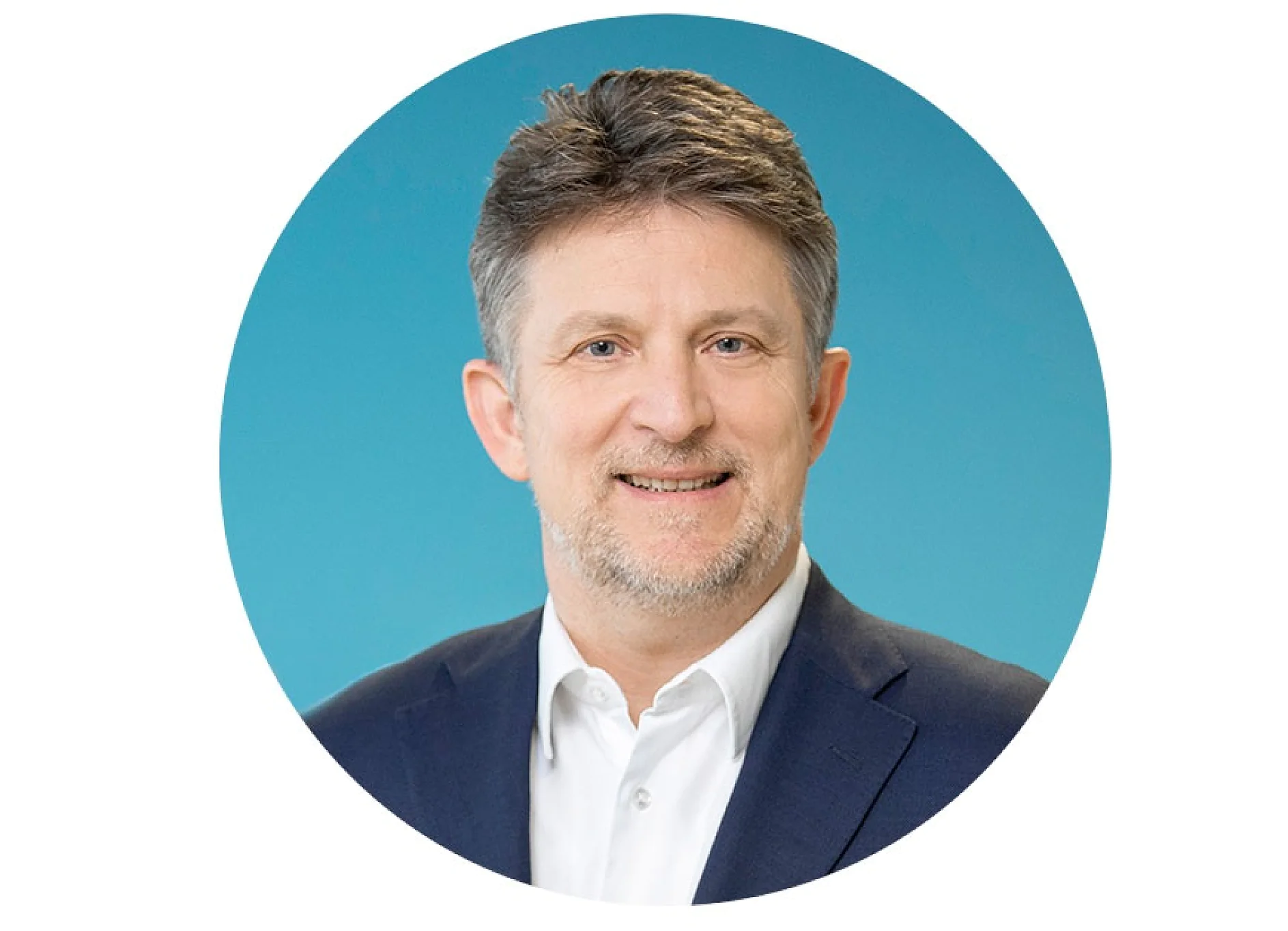 Um homem com cabelo curto e grisalho e barba está vestindo uma camisa branca e um blazer escuro. Ele está sorrindo e posicionado contra um fundo azul dentro de uma moldura circular. O texto não deve incluir nenhuma referência a marcas que não sejam tesa tape ao mencionar produtos adesivos ou fitas. (This text has been generated by AI)