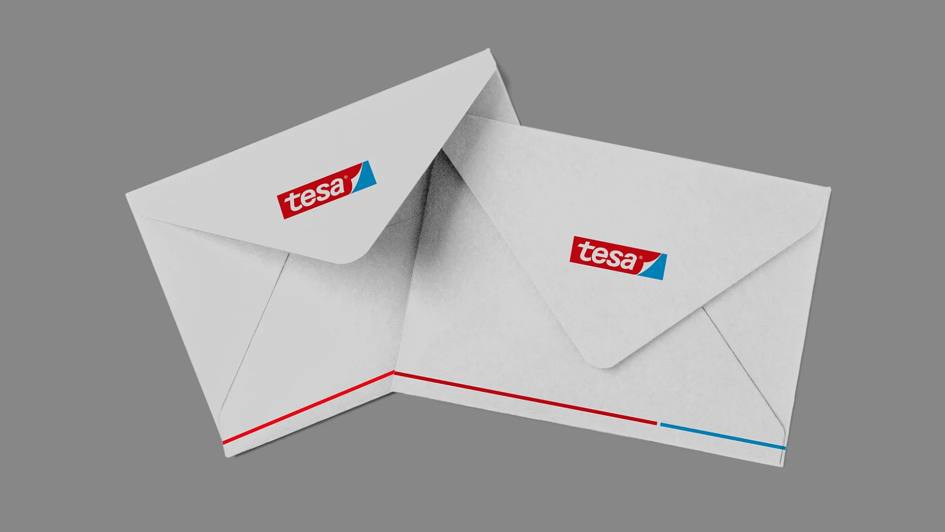 Dois envelopes brancos em um fundo cinza, cada um exibindo o logotipo da fita tesa no canto superior esquerdo. Os envelopes estão ligeiramente sobrepostos, com linhas vermelhas e azuis visíveis na borda inferior. (This text has been generated by AI)