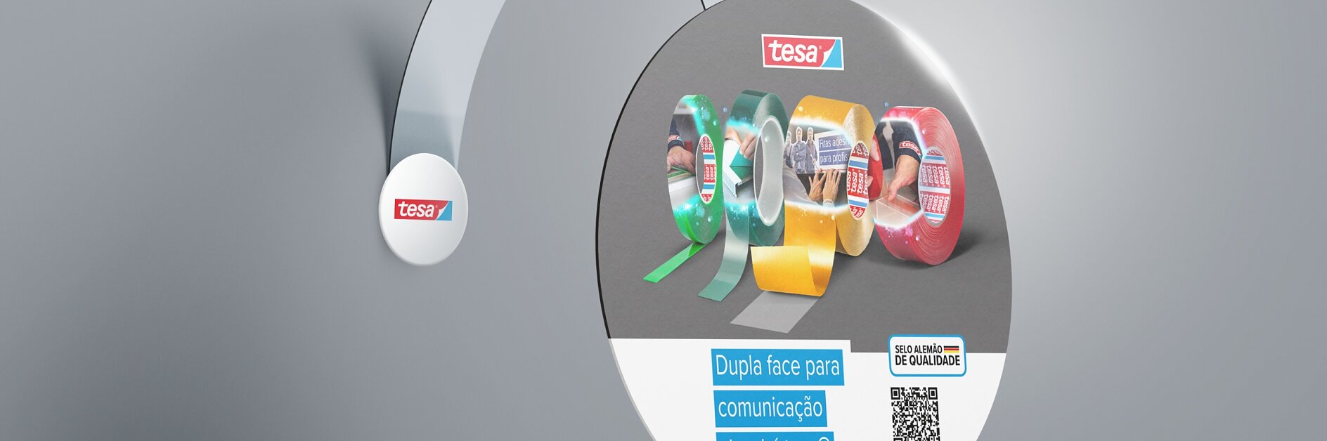 Exibição circular com uma seleção de fitas tesa em várias cores e larguras. O texto diz “Dupla face para comunicação visual é tesa®” com um código QR. O logotipo tesa® é proeminente. A foto tem um fundo metálico e minimalista. (This text has been generated by AI)