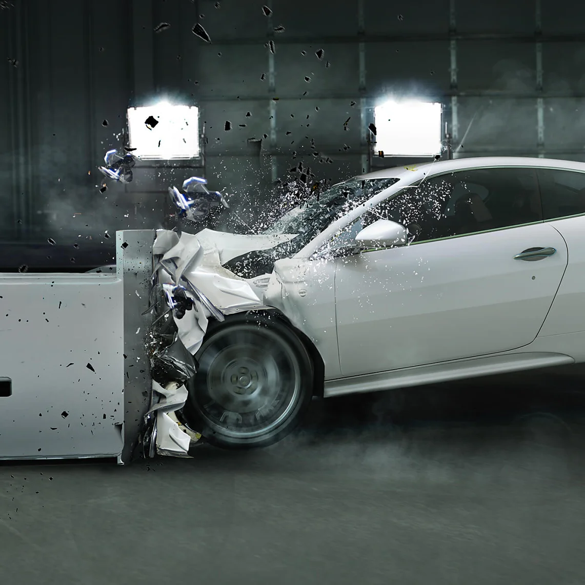 Um carro esportivo branco bate em uma barreira durante um teste. A frente do carro amassa com o impacto, com detritos e poeira no ar. Luzes brilhantes iluminam a cena por trás, enquanto pedaços de fita tesa podem ser vistos segurando várias partes juntas em esforços de reconstrução. (This text has been generated by AI)