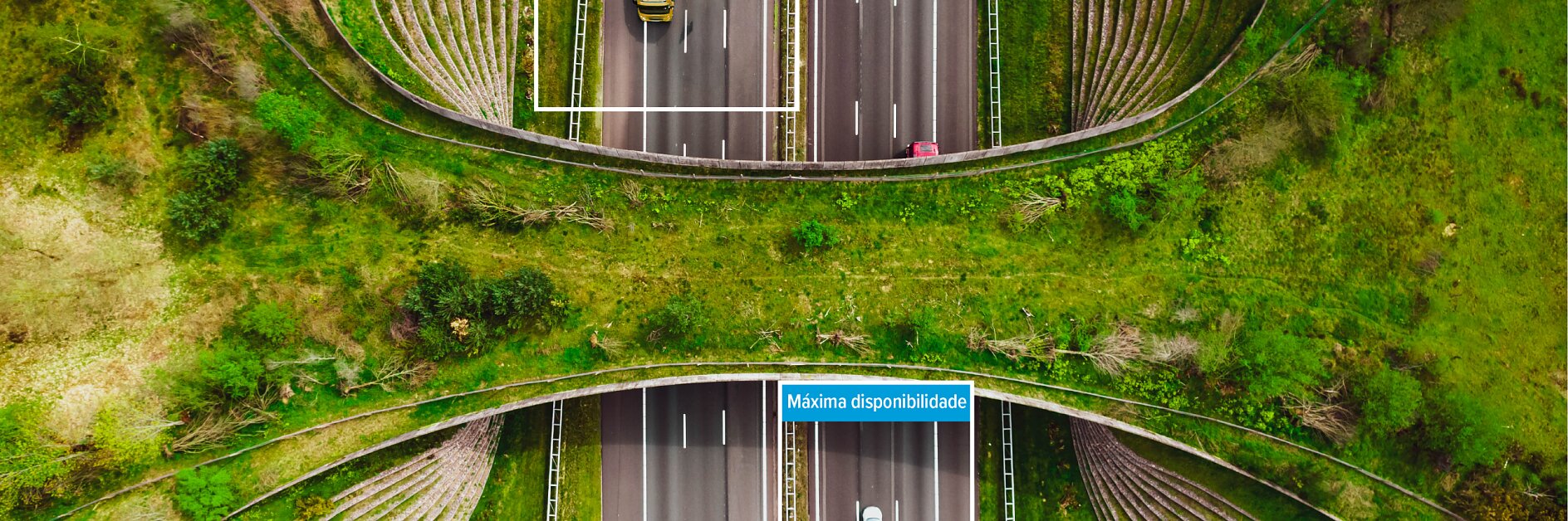 Vista aérea de duas rodovias sob uma ponte gramada, com carros visíveis. Caixas azuis com texto em português: Rotas tesa tape e Máxima disponibilidade.